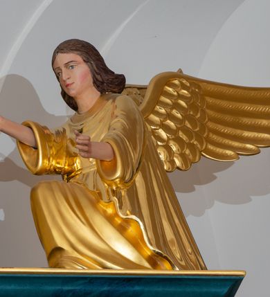 Zdjęcie nr 19: Ołtarz przyścienny, jednokondygnacyjny, jednoosiowy, ze zwieńczeniem. Ołtarz prostopadłościenny, tabernakulum z tronem wystawienia w formie architektonicznej na rzucie trapezoidalnym. W przedniej ściance wysokiego cokołu, o narożach ujętych spływami wolutowymi, są drzwiczki w kształcie prostokąta zamkniętego półkolistym łukiem nadwieszonym zdobione płaskorzeźbionym przedstawieniem kielicha eucharystycznego. Cokół wieńczy gzyms przekształcający się pośrodku w parę stykających się wolut. Na występach nad spływami cokołu osadzone kolumienki wspierające wyłamujące się ponad nimi belkowanie baldachimu tronu wystawienia. Zwieńczenie w formie pary stykających się spływów wolutowych z motywem paludamentu. Zaplecek zdobiony płycinami z ornamentalnymi obramieniami z motywami rocaille’u, w górnej partii płaskorzeźbiony trójkąt z okiem Opatrzności Bożej ujęty promienistą glorią. W zwieńczeniu para wazonów i para figurek aniołków, na szczycie księga z siedmioma pieczęciami i leżącym barankiem paschalnym.  
Retabulum osadzone na zdwojonym cokole, w górnej partii o zryzalitowanych bokach. Część środkową ujmują trzy pary kolumn, z których środkowe wysunięte, wspierających przerwane w partii architrawu i fryzu belkowanie. Zwieńczenie ujęte parą kolumn wspierających gzyms w formie trójkątnego przyczółka. Pola cokołu retabulum wypełnia stylizowana ornamentyka roślinna, partie fryzu oraz górne naroża części środkowej zdobią uskrzydlone główki anielskie, a gzyms kostkowanie. Zwieńczenie ujęte po bokach motywem liści paproci, pole ulistnionymi gałązkami z wstążką. Krawędź gzymsu wieńczącego zdobi wić roślinna z krzyżem pośrodku, po bokach para wazonów. Całość ujmuje para figur klęczących aniołów. Pole części środkowej w kształcie stojącego prostokąta ujętego profilowaną, złoconą ramą z przedstawieniem Narodzenia Najświętszej Marii Panny. W zwieńczeniu obraz w kształcie stojącego owalu, ujętego ramą zdobioną akantowymi liśćmi, z wizerunkiem św. Mikołaja. Struktura marmoryzowana w odcieniach błękitów, detal architektoniczny i ornamentyka złocone.   
