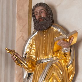 Zdjęcie nr 1: Całopostaciowa, drążona z tyłu figura św. Piotra stojącego na niewysokiej, ośmiobocznej podstawie. Święty zwrócony jest na wprost. Lekko przechyloną w prawo głowę charakteryzuje pociągła twarz o wyrazistych rysach z bruzdami na czole, mocno zarysowanymi łukami brwiowymi, wydatnym nosem i bujnym zarostem. Skręcone, ciemnobrązowe włosy sięgają ramion. Święty Piotr jest ubrany w długą, zapinaną na guziki, złoconą suknię przewiązaną srebrzonym pasem, na ramiona ma narzucony złocony płaszcz ze srebrzonym podszyciem, na stopach ciemnobrązowe, spiczaste buty. W zgiętych w łokciach, uniesionych na wysokości talii rękach ma parę złoconych kluczy – w prawej i otwartą, złocono-srebrzoną księgę – w lewej.    