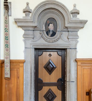 Zdjęcie nr 22: Świątynia otoczona jest murem kamiennym, tynkowanym, nakrytym daszkiem gontowym, jednospadowym. Wejścia znajdują się w murze od strony południowej. Pierwsze, prowadzące do głównych drzwi jest kamienną, późnobarokową bramką z herbem księdza Józefa Sawickiego, datą „1765” oraz figurą św. Jana Kantego. Drugie wejście prowadzi przez dzwonnicę. W murze, od strony wewnętrznej jest 14 wnęk po stacjach drogi krzyżowej. Teren wokół świątyni jest starym cmentarzem, bez zachowanych nagrobków.

Kościół jest budowlą założoną na planie prostokąta, orientowaną, jednonawową z ramionami w rodzaju krótkiego transeptu z wieżą od zachodu, zakrystią i kaplicą od północy oraz kruchtą od południa. Prezbiterium zamknięte jest wielobocznie, trójprzęsłowe, węższe i niższe od nawy. Nawa czteroprzęsłowa, nie jest ulokowana na jednej osi z prezbiterium. 

Artykulacja ścian jest przeprowadzona za pomocą pilastrów toskańskich podtrzymujących sklepienie kolebkowe z lunetami. Ramiona transeptu, kaplica Matki Boskiej Różańcowej oraz kruchta są sklepione krzyżowo. Otwory okienne: w prezbiterium cztery, w nawie cztery od południa, wszystkie zamknięte łukami półkolistymi. Zakrystia piętrowa z jednym oknem na parterze i dwoma na piętrze; od strony północnej kaplica Matki Boskiej Różańcowej z dwoma oknami i jedną, zamurowaną wnęką; obok mała zakrystia. Z prezbiterium do zakrystii prowadzi portal kamienny z inicjałami, herbem i portretem księdza Sawickiego. Na arkadzie tęczowej od strony nawy nowy napis: „FUNDATA A CASIMIRO MAGNO ANNO DOM[INI] 1346”. W pierwszym od strony fasady przęśle znajduje się drewniany chór muzyczny, wsparty na dwóch filarach.

Fasada zachodnia kościoła jest płaska z wieżą, nakryta kopułą z latarnią. Na narożnikach zewnętrznych wieży i naw oraz przy absydzie szkarpy, kryte daszkiem gontowym. Na frontowej ścianie wieży kamienny portal, nad nim sygle „I(osephus) S(awicki) / 1765” oraz herb Nowina. Od strony zachodniej wieża, ozdobiona półkolistymi blendami. Od strony południowej balkonik otoczony żelazną kratą z napisem „1343-1943”. Nad balkonikiem umieszczona jest tarcza zegara, taka sama widnieje od strony północnej, a od zachodniej i wschodniej odpowiadają im tarcze w murze. Przy wieży, od strony północnej wieżyczka w kształcie walca, ścięta od połowy, nakryta daszkiem stożkowym. Przy południowej ścianie wieży między dwiema szkarpami znajduje się kapliczka Ukrzyżowania z figurami Chrystusa Ukrzyżowanego i dwóch łotrów na krzyżach. Dach kościoła siodłowy, kryty gontem.

Na zewnętrznej, południowej ścianie napis: „AEDIFICATA H(A)EC EC[C]LESIA / A[NNO] D[OMINI] / 1606 / PETRVS CZARNY MVLARS”. Niżej wmurowana w półokrągłą wnękę z piaskowca figura Matki Boskiej Niepokalanie Poczętej. Po lewej stronie, u góry fragment fryzu dekoracyjnego, malowany w kolorze czerwonym o motywie zwisających esownic ze stylizowanymi kwiatami i liliami. 

Dzwonnica na planie kwadratu, murowana, otynkowana, dwupiętrowa z sienią przejściową sklepioną, ujętą na zaokrąglonych narożnikach zdwojonymi pilastrami; nakryta gontowym hełmem. Na osi dzwonnicy portal bramy flankowany dwoma pilastrami, o spłaszczonej archiwolcie. Nad belkowaniem monogram maryjny i data „1701”. W sieni na ścianie wschodniej barokowy krucyfiks oraz rzeźby Matki Boskiej i św. Jana Ewangelisty, na ścianie pozostałości polichromii z XVIII wieku.
