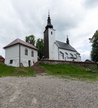 Zdjęcie nr 35: Kościół św. Piotra i św. Pawła jest usytuowany w centrum Łapsz Wyżnych, na południe od głównej drogi z Trybsza do Łapsz Niżnych. Teren przykościelny jest otoczony wysokim kamiennym i częściowo otynkowanym murem, nakrytym gontem od strony wschodniej, zachodniej i północnej oraz nakrytym blachą od strony południowej; daszki jednospadowe, nachylone na zewnątrz. W części zachodniej muru zlokalizowana jest szeroka brama, flankowana dwoma masywnymi filarami, na których ustawione są okrągłe słupy, przykryte stożkowym daszkiem gontowym i zwieńczone krzyżykami. Od wschodu analogiczne wejście z szerszym przejściem, dostępnym schodkami. Trzecie wejście na teren przykościelny prowadzi od północy przez bramę w kształcie arkady zamkniętej łukiem odcinkowym, zwieńczonej trójkątnym nadprożem, na którego szczycie ustawiony jest krzyż i wazony po bokach. Czwarte wejście zlokalizowane w zachodnio-południowym narożniku muru prowadzi przez wysokie schody z balustradą. Od zachodu w ogrodzeniu ulokowany jest budynek salki katechetycznej (dawna kostnica) wchodzącej w mur ścianą frontową. W obrębie placu przykościelnego znajdują się resztki cmentarza w postaci kamiennych i granitowych nagrobków oraz żeliwnych krzyży. 

Kościół jest orientowany, murowany, otynkowany, jednonawowy z czworoboczną wieżą w fasadzie z prezbiterium zamkniętym półkoliście. Dwuprzęsłowe prezbiterium oddziela od nawy ściana arkady tęczowej. Nawa jest szersza, trójprzęsłowa. Wnętrze artykułowane pilastrami wspierającymi sklepienie kolebkowe z lunetami na gurtach, ozdobione stiukowymi, późnobarokowymi ramami. Od południa do prezbiterium przylega zakrystia na planie prostokąta, a do nawy od północny kruchta z portalem z zaakcentowaną datą: „1760”. Na zachodniej ścianie nawy chór muzyczny wsparty jest na trzech półkolistych arkadach. 

Wnętrze oświetlają umieszczone w południowych i północnych ścianach nawy prostokątne, zamknięte półkoliście cztery okna, takie same dwa znajdują się w prezbiterium; w wieży trzy podobne okna umieszczone po jednym z każdej strony, oprócz ściany zachodniej; w apsydzie jedno małe, okrągłe okno. Do kościoła prowadzi główne wejście od strony zachodniej oraz dwa mniejsze od strony północnej przez kruchtę i od strony południowej przez zakrystię.

W zewnętrznej elewacji kościoła widoczny jest niewysoki, kamienny cokół, powyżej kościół jest otynkowany. Prezbiterium, niższe od nawy. Nawa oszkarpowana, nakryta dachem dwuspadowym z wieżą na sygnaturkę na skrzyżowaniu na wschodnim zakończeniu nawy. Do zachodniej fasady kościoła dostawiona jest wysoka założona na planie kwadratu wieża-dzwonnica. W dolnej kondygnacji na osi kościoła znajduje się prostokątne wejście do kruchty, zamknięte półkoliście. Fasada wieży w całości pokryta jest blachą, przechodzącą nad głównym wejściem do kościoła w daszek. Hełm wieży baniasty z latarnią.
