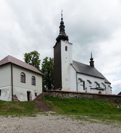 Zdjęcie nr 36: Kościół św. Piotra i św. Pawła jest usytuowany w centrum Łapsz Wyżnych, na południe od głównej drogi z Trybsza do Łapsz Niżnych. Teren przykościelny jest otoczony wysokim kamiennym i częściowo otynkowanym murem, nakrytym gontem od strony wschodniej, zachodniej i północnej oraz nakrytym blachą od strony południowej; daszki jednospadowe, nachylone na zewnątrz. W części zachodniej muru zlokalizowana jest szeroka brama, flankowana dwoma masywnymi filarami, na których ustawione są okrągłe słupy, przykryte stożkowym daszkiem gontowym i zwieńczone krzyżykami. Od wschodu analogiczne wejście z szerszym przejściem, dostępnym schodkami. Trzecie wejście na teren przykościelny prowadzi od północy przez bramę w kształcie arkady zamkniętej łukiem odcinkowym, zwieńczonej trójkątnym nadprożem, na którego szczycie ustawiony jest krzyż i wazony po bokach. Czwarte wejście zlokalizowane w zachodnio-południowym narożniku muru prowadzi przez wysokie schody z balustradą. Od zachodu w ogrodzeniu ulokowany jest budynek salki katechetycznej (dawna kostnica) wchodzącej w mur ścianą frontową. W obrębie placu przykościelnego znajdują się resztki cmentarza w postaci kamiennych i granitowych nagrobków oraz żeliwnych krzyży. 

Kościół jest orientowany, murowany, otynkowany, jednonawowy z czworoboczną wieżą w fasadzie z prezbiterium zamkniętym półkoliście. Dwuprzęsłowe prezbiterium oddziela od nawy ściana arkady tęczowej. Nawa jest szersza, trójprzęsłowa. Wnętrze artykułowane pilastrami wspierającymi sklepienie kolebkowe z lunetami na gurtach, ozdobione stiukowymi, późnobarokowymi ramami. Od południa do prezbiterium przylega zakrystia na planie prostokąta, a do nawy od północny kruchta z portalem z zaakcentowaną datą: „1760”. Na zachodniej ścianie nawy chór muzyczny wsparty jest na trzech półkolistych arkadach. 

Wnętrze oświetlają umieszczone w południowych i północnych ścianach nawy prostokątne, zamknięte półkoliście cztery okna, takie same dwa znajdują się w prezbiterium; w wieży trzy podobne okna umieszczone po jednym z każdej strony, oprócz ściany zachodniej; w apsydzie jedno małe, okrągłe okno. Do kościoła prowadzi główne wejście od strony zachodniej oraz dwa mniejsze od strony północnej przez kruchtę i od strony południowej przez zakrystię.

W zewnętrznej elewacji kościoła widoczny jest niewysoki, kamienny cokół, powyżej kościół jest otynkowany. Prezbiterium, niższe od nawy. Nawa oszkarpowana, nakryta dachem dwuspadowym z wieżą na sygnaturkę na skrzyżowaniu na wschodnim zakończeniu nawy. Do zachodniej fasady kościoła dostawiona jest wysoka założona na planie kwadratu wieża-dzwonnica. W dolnej kondygnacji na osi kościoła znajduje się prostokątne wejście do kruchty, zamknięte półkoliście. Fasada wieży w całości pokryta jest blachą, przechodzącą nad głównym wejściem do kościoła w daszek. Hełm wieży baniasty z latarnią.
