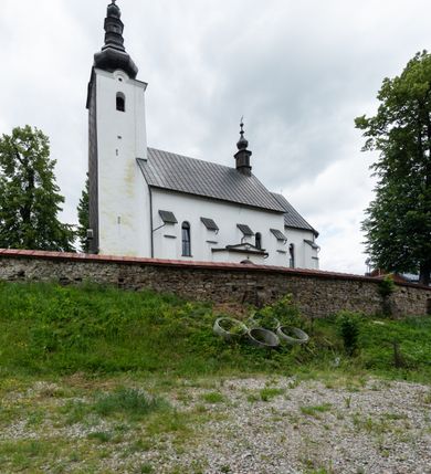 Zdjęcie nr 2: Kościół św. Piotra i św. Pawła jest usytuowany w centrum Łapsz Wyżnych, na południe od głównej drogi z Trybsza do Łapsz Niżnych. Teren przykościelny jest otoczony wysokim kamiennym i częściowo otynkowanym murem, nakrytym gontem od strony wschodniej, zachodniej i północnej oraz nakrytym blachą od strony południowej; daszki jednospadowe, nachylone na zewnątrz. W części zachodniej muru zlokalizowana jest szeroka brama, flankowana dwoma masywnymi filarami, na których ustawione są okrągłe słupy, przykryte stożkowym daszkiem gontowym i zwieńczone krzyżykami. Od wschodu analogiczne wejście z szerszym przejściem, dostępnym schodkami. Trzecie wejście na teren przykościelny prowadzi od północy przez bramę w kształcie arkady zamkniętej łukiem odcinkowym, zwieńczonej trójkątnym nadprożem, na którego szczycie ustawiony jest krzyż i wazony po bokach. Czwarte wejście zlokalizowane w zachodnio-południowym narożniku muru prowadzi przez wysokie schody z balustradą. Od zachodu w ogrodzeniu ulokowany jest budynek salki katechetycznej (dawna kostnica) wchodzącej w mur ścianą frontową. W obrębie placu przykościelnego znajdują się resztki cmentarza w postaci kamiennych i granitowych nagrobków oraz żeliwnych krzyży. 

Kościół jest orientowany, murowany, otynkowany, jednonawowy z czworoboczną wieżą w fasadzie z prezbiterium zamkniętym półkoliście. Dwuprzęsłowe prezbiterium oddziela od nawy ściana arkady tęczowej. Nawa jest szersza, trójprzęsłowa. Wnętrze artykułowane pilastrami wspierającymi sklepienie kolebkowe z lunetami na gurtach, ozdobione stiukowymi, późnobarokowymi ramami. Od południa do prezbiterium przylega zakrystia na planie prostokąta, a do nawy od północny kruchta z portalem z zaakcentowaną datą: „1760”. Na zachodniej ścianie nawy chór muzyczny wsparty jest na trzech półkolistych arkadach. 

Wnętrze oświetlają umieszczone w południowych i północnych ścianach nawy prostokątne, zamknięte półkoliście cztery okna, takie same dwa znajdują się w prezbiterium; w wieży trzy podobne okna umieszczone po jednym z każdej strony, oprócz ściany zachodniej; w apsydzie jedno małe, okrągłe okno. Do kościoła prowadzi główne wejście od strony zachodniej oraz dwa mniejsze od strony północnej przez kruchtę i od strony południowej przez zakrystię.

W zewnętrznej elewacji kościoła widoczny jest niewysoki, kamienny cokół, powyżej kościół jest otynkowany. Prezbiterium, niższe od nawy. Nawa oszkarpowana, nakryta dachem dwuspadowym z wieżą na sygnaturkę na skrzyżowaniu na wschodnim zakończeniu nawy. Do zachodniej fasady kościoła dostawiona jest wysoka założona na planie kwadratu wieża-dzwonnica. W dolnej kondygnacji na osi kościoła znajduje się prostokątne wejście do kruchty, zamknięte półkoliście. Fasada wieży w całości pokryta jest blachą, przechodzącą nad głównym wejściem do kościoła w daszek. Hełm wieży baniasty z latarnią.

