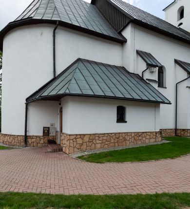 Zdjęcie nr 7: Kościół św. Piotra i św. Pawła jest usytuowany w centrum Łapsz Wyżnych, na południe od głównej drogi z Trybsza do Łapsz Niżnych. Teren przykościelny jest otoczony wysokim kamiennym i częściowo otynkowanym murem, nakrytym gontem od strony wschodniej, zachodniej i północnej oraz nakrytym blachą od strony południowej; daszki jednospadowe, nachylone na zewnątrz. W części zachodniej muru zlokalizowana jest szeroka brama, flankowana dwoma masywnymi filarami, na których ustawione są okrągłe słupy, przykryte stożkowym daszkiem gontowym i zwieńczone krzyżykami. Od wschodu analogiczne wejście z szerszym przejściem, dostępnym schodkami. Trzecie wejście na teren przykościelny prowadzi od północy przez bramę w kształcie arkady zamkniętej łukiem odcinkowym, zwieńczonej trójkątnym nadprożem, na którego szczycie ustawiony jest krzyż i wazony po bokach. Czwarte wejście zlokalizowane w zachodnio-południowym narożniku muru prowadzi przez wysokie schody z balustradą. Od zachodu w ogrodzeniu ulokowany jest budynek salki katechetycznej (dawna kostnica) wchodzącej w mur ścianą frontową. W obrębie placu przykościelnego znajdują się resztki cmentarza w postaci kamiennych i granitowych nagrobków oraz żeliwnych krzyży. 

Kościół jest orientowany, murowany, otynkowany, jednonawowy z czworoboczną wieżą w fasadzie z prezbiterium zamkniętym półkoliście. Dwuprzęsłowe prezbiterium oddziela od nawy ściana arkady tęczowej. Nawa jest szersza, trójprzęsłowa. Wnętrze artykułowane pilastrami wspierającymi sklepienie kolebkowe z lunetami na gurtach, ozdobione stiukowymi, późnobarokowymi ramami. Od południa do prezbiterium przylega zakrystia na planie prostokąta, a do nawy od północny kruchta z portalem z zaakcentowaną datą: „1760”. Na zachodniej ścianie nawy chór muzyczny wsparty jest na trzech półkolistych arkadach. 

Wnętrze oświetlają umieszczone w południowych i północnych ścianach nawy prostokątne, zamknięte półkoliście cztery okna, takie same dwa znajdują się w prezbiterium; w wieży trzy podobne okna umieszczone po jednym z każdej strony, oprócz ściany zachodniej; w apsydzie jedno małe, okrągłe okno. Do kościoła prowadzi główne wejście od strony zachodniej oraz dwa mniejsze od strony północnej przez kruchtę i od strony południowej przez zakrystię.

W zewnętrznej elewacji kościoła widoczny jest niewysoki, kamienny cokół, powyżej kościół jest otynkowany. Prezbiterium, niższe od nawy. Nawa oszkarpowana, nakryta dachem dwuspadowym z wieżą na sygnaturkę na skrzyżowaniu na wschodnim zakończeniu nawy. Do zachodniej fasady kościoła dostawiona jest wysoka założona na planie kwadratu wieża-dzwonnica. W dolnej kondygnacji na osi kościoła znajduje się prostokątne wejście do kruchty, zamknięte półkoliście. Fasada wieży w całości pokryta jest blachą, przechodzącą nad głównym wejściem do kościoła w daszek. Hełm wieży baniasty z latarnią.
