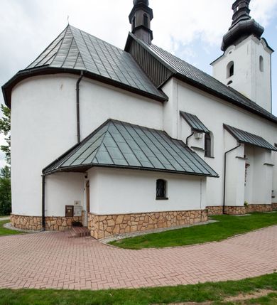 Zdjęcie nr 5: Kościół św. Piotra i św. Pawła jest usytuowany w centrum Łapsz Wyżnych, na południe od głównej drogi z Trybsza do Łapsz Niżnych. Teren przykościelny jest otoczony wysokim kamiennym i częściowo otynkowanym murem, nakrytym gontem od strony wschodniej, zachodniej i północnej oraz nakrytym blachą od strony południowej; daszki jednospadowe, nachylone na zewnątrz. W części zachodniej muru zlokalizowana jest szeroka brama, flankowana dwoma masywnymi filarami, na których ustawione są okrągłe słupy, przykryte stożkowym daszkiem gontowym i zwieńczone krzyżykami. Od wschodu analogiczne wejście z szerszym przejściem, dostępnym schodkami. Trzecie wejście na teren przykościelny prowadzi od północy przez bramę w kształcie arkady zamkniętej łukiem odcinkowym, zwieńczonej trójkątnym nadprożem, na którego szczycie ustawiony jest krzyż i wazony po bokach. Czwarte wejście zlokalizowane w zachodnio-południowym narożniku muru prowadzi przez wysokie schody z balustradą. Od zachodu w ogrodzeniu ulokowany jest budynek salki katechetycznej (dawna kostnica) wchodzącej w mur ścianą frontową. W obrębie placu przykościelnego znajdują się resztki cmentarza w postaci kamiennych i granitowych nagrobków oraz żeliwnych krzyży. 

Kościół jest orientowany, murowany, otynkowany, jednonawowy z czworoboczną wieżą w fasadzie z prezbiterium zamkniętym półkoliście. Dwuprzęsłowe prezbiterium oddziela od nawy ściana arkady tęczowej. Nawa jest szersza, trójprzęsłowa. Wnętrze artykułowane pilastrami wspierającymi sklepienie kolebkowe z lunetami na gurtach, ozdobione stiukowymi, późnobarokowymi ramami. Od południa do prezbiterium przylega zakrystia na planie prostokąta, a do nawy od północny kruchta z portalem z zaakcentowaną datą: „1760”. Na zachodniej ścianie nawy chór muzyczny wsparty jest na trzech półkolistych arkadach. 

Wnętrze oświetlają umieszczone w południowych i północnych ścianach nawy prostokątne, zamknięte półkoliście cztery okna, takie same dwa znajdują się w prezbiterium; w wieży trzy podobne okna umieszczone po jednym z każdej strony, oprócz ściany zachodniej; w apsydzie jedno małe, okrągłe okno. Do kościoła prowadzi główne wejście od strony zachodniej oraz dwa mniejsze od strony północnej przez kruchtę i od strony południowej przez zakrystię.

W zewnętrznej elewacji kościoła widoczny jest niewysoki, kamienny cokół, powyżej kościół jest otynkowany. Prezbiterium, niższe od nawy. Nawa oszkarpowana, nakryta dachem dwuspadowym z wieżą na sygnaturkę na skrzyżowaniu na wschodnim zakończeniu nawy. Do zachodniej fasady kościoła dostawiona jest wysoka założona na planie kwadratu wieża-dzwonnica. W dolnej kondygnacji na osi kościoła znajduje się prostokątne wejście do kruchty, zamknięte półkoliście. Fasada wieży w całości pokryta jest blachą, przechodzącą nad głównym wejściem do kościoła w daszek. Hełm wieży baniasty z latarnią.
