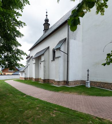 Zdjęcie nr 9: Kościół św. Piotra i św. Pawła jest usytuowany w centrum Łapsz Wyżnych, na południe od głównej drogi z Trybsza do Łapsz Niżnych. Teren przykościelny jest otoczony wysokim kamiennym i częściowo otynkowanym murem, nakrytym gontem od strony wschodniej, zachodniej i północnej oraz nakrytym blachą od strony południowej; daszki jednospadowe, nachylone na zewnątrz. W części zachodniej muru zlokalizowana jest szeroka brama, flankowana dwoma masywnymi filarami, na których ustawione są okrągłe słupy, przykryte stożkowym daszkiem gontowym i zwieńczone krzyżykami. Od wschodu analogiczne wejście z szerszym przejściem, dostępnym schodkami. Trzecie wejście na teren przykościelny prowadzi od północy przez bramę w kształcie arkady zamkniętej łukiem odcinkowym, zwieńczonej trójkątnym nadprożem, na którego szczycie ustawiony jest krzyż i wazony po bokach. Czwarte wejście zlokalizowane w zachodnio-południowym narożniku muru prowadzi przez wysokie schody z balustradą. Od zachodu w ogrodzeniu ulokowany jest budynek salki katechetycznej (dawna kostnica) wchodzącej w mur ścianą frontową. W obrębie placu przykościelnego znajdują się resztki cmentarza w postaci kamiennych i granitowych nagrobków oraz żeliwnych krzyży. 

Kościół jest orientowany, murowany, otynkowany, jednonawowy z czworoboczną wieżą w fasadzie z prezbiterium zamkniętym półkoliście. Dwuprzęsłowe prezbiterium oddziela od nawy ściana arkady tęczowej. Nawa jest szersza, trójprzęsłowa. Wnętrze artykułowane pilastrami wspierającymi sklepienie kolebkowe z lunetami na gurtach, ozdobione stiukowymi, późnobarokowymi ramami. Od południa do prezbiterium przylega zakrystia na planie prostokąta, a do nawy od północny kruchta z portalem z zaakcentowaną datą: „1760”. Na zachodniej ścianie nawy chór muzyczny wsparty jest na trzech półkolistych arkadach. 

Wnętrze oświetlają umieszczone w południowych i północnych ścianach nawy prostokątne, zamknięte półkoliście cztery okna, takie same dwa znajdują się w prezbiterium; w wieży trzy podobne okna umieszczone po jednym z każdej strony, oprócz ściany zachodniej; w apsydzie jedno małe, okrągłe okno. Do kościoła prowadzi główne wejście od strony zachodniej oraz dwa mniejsze od strony północnej przez kruchtę i od strony południowej przez zakrystię.

W zewnętrznej elewacji kościoła widoczny jest niewysoki, kamienny cokół, powyżej kościół jest otynkowany. Prezbiterium, niższe od nawy. Nawa oszkarpowana, nakryta dachem dwuspadowym z wieżą na sygnaturkę na skrzyżowaniu na wschodnim zakończeniu nawy. Do zachodniej fasady kościoła dostawiona jest wysoka założona na planie kwadratu wieża-dzwonnica. W dolnej kondygnacji na osi kościoła znajduje się prostokątne wejście do kruchty, zamknięte półkoliście. Fasada wieży w całości pokryta jest blachą, przechodzącą nad głównym wejściem do kościoła w daszek. Hełm wieży baniasty z latarnią.
