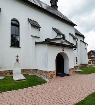 Zdjęcie nr 15: Kościół św. Piotra i św. Pawła jest usytuowany w centrum Łapsz Wyżnych, na południe od głównej drogi z Trybsza do Łapsz Niżnych. Teren przykościelny jest otoczony wysokim kamiennym i częściowo otynkowanym murem, nakrytym gontem od strony wschodniej, zachodniej i północnej oraz nakrytym blachą od strony południowej; daszki jednospadowe, nachylone na zewnątrz. W części zachodniej muru zlokalizowana jest szeroka brama, flankowana dwoma masywnymi filarami, na których ustawione są okrągłe słupy, przykryte stożkowym daszkiem gontowym i zwieńczone krzyżykami. Od wschodu analogiczne wejście z szerszym przejściem, dostępnym schodkami. Trzecie wejście na teren przykościelny prowadzi od północy przez bramę w kształcie arkady zamkniętej łukiem odcinkowym, zwieńczonej trójkątnym nadprożem, na którego szczycie ustawiony jest krzyż i wazony po bokach. Czwarte wejście zlokalizowane w zachodnio-południowym narożniku muru prowadzi przez wysokie schody z balustradą. Od zachodu w ogrodzeniu ulokowany jest budynek salki katechetycznej (dawna kostnica) wchodzącej w mur ścianą frontową. W obrębie placu przykościelnego znajdują się resztki cmentarza w postaci kamiennych i granitowych nagrobków oraz żeliwnych krzyży. 

Kościół jest orientowany, murowany, otynkowany, jednonawowy z czworoboczną wieżą w fasadzie z prezbiterium zamkniętym półkoliście. Dwuprzęsłowe prezbiterium oddziela od nawy ściana arkady tęczowej. Nawa jest szersza, trójprzęsłowa. Wnętrze artykułowane pilastrami wspierającymi sklepienie kolebkowe z lunetami na gurtach, ozdobione stiukowymi, późnobarokowymi ramami. Od południa do prezbiterium przylega zakrystia na planie prostokąta, a do nawy od północny kruchta z portalem z zaakcentowaną datą: „1760”. Na zachodniej ścianie nawy chór muzyczny wsparty jest na trzech półkolistych arkadach. 

Wnętrze oświetlają umieszczone w południowych i północnych ścianach nawy prostokątne, zamknięte półkoliście cztery okna, takie same dwa znajdują się w prezbiterium; w wieży trzy podobne okna umieszczone po jednym z każdej strony, oprócz ściany zachodniej; w apsydzie jedno małe, okrągłe okno. Do kościoła prowadzi główne wejście od strony zachodniej oraz dwa mniejsze od strony północnej przez kruchtę i od strony południowej przez zakrystię.

W zewnętrznej elewacji kościoła widoczny jest niewysoki, kamienny cokół, powyżej kościół jest otynkowany. Prezbiterium, niższe od nawy. Nawa oszkarpowana, nakryta dachem dwuspadowym z wieżą na sygnaturkę na skrzyżowaniu na wschodnim zakończeniu nawy. Do zachodniej fasady kościoła dostawiona jest wysoka założona na planie kwadratu wieża-dzwonnica. W dolnej kondygnacji na osi kościoła znajduje się prostokątne wejście do kruchty, zamknięte półkoliście. Fasada wieży w całości pokryta jest blachą, przechodzącą nad głównym wejściem do kościoła w daszek. Hełm wieży baniasty z latarnią.
