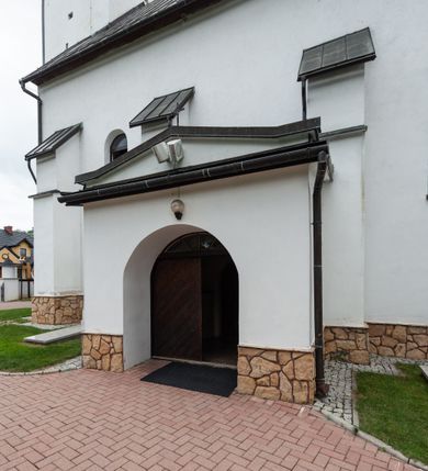 Zdjęcie nr 14: Kościół św. Piotra i św. Pawła jest usytuowany w centrum Łapsz Wyżnych, na południe od głównej drogi z Trybsza do Łapsz Niżnych. Teren przykościelny jest otoczony wysokim kamiennym i częściowo otynkowanym murem, nakrytym gontem od strony wschodniej, zachodniej i północnej oraz nakrytym blachą od strony południowej; daszki jednospadowe, nachylone na zewnątrz. W części zachodniej muru zlokalizowana jest szeroka brama, flankowana dwoma masywnymi filarami, na których ustawione są okrągłe słupy, przykryte stożkowym daszkiem gontowym i zwieńczone krzyżykami. Od wschodu analogiczne wejście z szerszym przejściem, dostępnym schodkami. Trzecie wejście na teren przykościelny prowadzi od północy przez bramę w kształcie arkady zamkniętej łukiem odcinkowym, zwieńczonej trójkątnym nadprożem, na którego szczycie ustawiony jest krzyż i wazony po bokach. Czwarte wejście zlokalizowane w zachodnio-południowym narożniku muru prowadzi przez wysokie schody z balustradą. Od zachodu w ogrodzeniu ulokowany jest budynek salki katechetycznej (dawna kostnica) wchodzącej w mur ścianą frontową. W obrębie placu przykościelnego znajdują się resztki cmentarza w postaci kamiennych i granitowych nagrobków oraz żeliwnych krzyży. 

Kościół jest orientowany, murowany, otynkowany, jednonawowy z czworoboczną wieżą w fasadzie z prezbiterium zamkniętym półkoliście. Dwuprzęsłowe prezbiterium oddziela od nawy ściana arkady tęczowej. Nawa jest szersza, trójprzęsłowa. Wnętrze artykułowane pilastrami wspierającymi sklepienie kolebkowe z lunetami na gurtach, ozdobione stiukowymi, późnobarokowymi ramami. Od południa do prezbiterium przylega zakrystia na planie prostokąta, a do nawy od północny kruchta z portalem z zaakcentowaną datą: „1760”. Na zachodniej ścianie nawy chór muzyczny wsparty jest na trzech półkolistych arkadach. 

Wnętrze oświetlają umieszczone w południowych i północnych ścianach nawy prostokątne, zamknięte półkoliście cztery okna, takie same dwa znajdują się w prezbiterium; w wieży trzy podobne okna umieszczone po jednym z każdej strony, oprócz ściany zachodniej; w apsydzie jedno małe, okrągłe okno. Do kościoła prowadzi główne wejście od strony zachodniej oraz dwa mniejsze od strony północnej przez kruchtę i od strony południowej przez zakrystię.

W zewnętrznej elewacji kościoła widoczny jest niewysoki, kamienny cokół, powyżej kościół jest otynkowany. Prezbiterium, niższe od nawy. Nawa oszkarpowana, nakryta dachem dwuspadowym z wieżą na sygnaturkę na skrzyżowaniu na wschodnim zakończeniu nawy. Do zachodniej fasady kościoła dostawiona jest wysoka założona na planie kwadratu wieża-dzwonnica. W dolnej kondygnacji na osi kościoła znajduje się prostokątne wejście do kruchty, zamknięte półkoliście. Fasada wieży w całości pokryta jest blachą, przechodzącą nad głównym wejściem do kościoła w daszek. Hełm wieży baniasty z latarnią.
