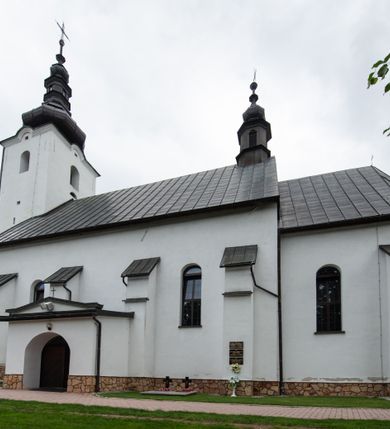 Zdjęcie nr 12: Kościół św. Piotra i św. Pawła jest usytuowany w centrum Łapsz Wyżnych, na południe od głównej drogi z Trybsza do Łapsz Niżnych. Teren przykościelny jest otoczony wysokim kamiennym i częściowo otynkowanym murem, nakrytym gontem od strony wschodniej, zachodniej i północnej oraz nakrytym blachą od strony południowej; daszki jednospadowe, nachylone na zewnątrz. W części zachodniej muru zlokalizowana jest szeroka brama, flankowana dwoma masywnymi filarami, na których ustawione są okrągłe słupy, przykryte stożkowym daszkiem gontowym i zwieńczone krzyżykami. Od wschodu analogiczne wejście z szerszym przejściem, dostępnym schodkami. Trzecie wejście na teren przykościelny prowadzi od północy przez bramę w kształcie arkady zamkniętej łukiem odcinkowym, zwieńczonej trójkątnym nadprożem, na którego szczycie ustawiony jest krzyż i wazony po bokach. Czwarte wejście zlokalizowane w zachodnio-południowym narożniku muru prowadzi przez wysokie schody z balustradą. Od zachodu w ogrodzeniu ulokowany jest budynek salki katechetycznej (dawna kostnica) wchodzącej w mur ścianą frontową. W obrębie placu przykościelnego znajdują się resztki cmentarza w postaci kamiennych i granitowych nagrobków oraz żeliwnych krzyży. 

Kościół jest orientowany, murowany, otynkowany, jednonawowy z czworoboczną wieżą w fasadzie z prezbiterium zamkniętym półkoliście. Dwuprzęsłowe prezbiterium oddziela od nawy ściana arkady tęczowej. Nawa jest szersza, trójprzęsłowa. Wnętrze artykułowane pilastrami wspierającymi sklepienie kolebkowe z lunetami na gurtach, ozdobione stiukowymi, późnobarokowymi ramami. Od południa do prezbiterium przylega zakrystia na planie prostokąta, a do nawy od północny kruchta z portalem z zaakcentowaną datą: „1760”. Na zachodniej ścianie nawy chór muzyczny wsparty jest na trzech półkolistych arkadach. 

Wnętrze oświetlają umieszczone w południowych i północnych ścianach nawy prostokątne, zamknięte półkoliście cztery okna, takie same dwa znajdują się w prezbiterium; w wieży trzy podobne okna umieszczone po jednym z każdej strony, oprócz ściany zachodniej; w apsydzie jedno małe, okrągłe okno. Do kościoła prowadzi główne wejście od strony zachodniej oraz dwa mniejsze od strony północnej przez kruchtę i od strony południowej przez zakrystię.

W zewnętrznej elewacji kościoła widoczny jest niewysoki, kamienny cokół, powyżej kościół jest otynkowany. Prezbiterium, niższe od nawy. Nawa oszkarpowana, nakryta dachem dwuspadowym z wieżą na sygnaturkę na skrzyżowaniu na wschodnim zakończeniu nawy. Do zachodniej fasady kościoła dostawiona jest wysoka założona na planie kwadratu wieża-dzwonnica. W dolnej kondygnacji na osi kościoła znajduje się prostokątne wejście do kruchty, zamknięte półkoliście. Fasada wieży w całości pokryta jest blachą, przechodzącą nad głównym wejściem do kościoła w daszek. Hełm wieży baniasty z latarnią.
