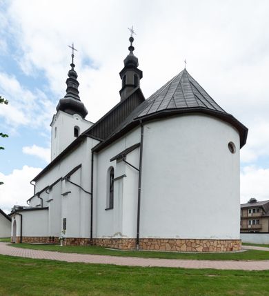 Zdjęcie nr 20: Kościół św. Piotra i św. Pawła jest usytuowany w centrum Łapsz Wyżnych, na południe od głównej drogi z Trybsza do Łapsz Niżnych. Teren przykościelny jest otoczony wysokim kamiennym i częściowo otynkowanym murem, nakrytym gontem od strony wschodniej, zachodniej i północnej oraz nakrytym blachą od strony południowej; daszki jednospadowe, nachylone na zewnątrz. W części zachodniej muru zlokalizowana jest szeroka brama, flankowana dwoma masywnymi filarami, na których ustawione są okrągłe słupy, przykryte stożkowym daszkiem gontowym i zwieńczone krzyżykami. Od wschodu analogiczne wejście z szerszym przejściem, dostępnym schodkami. Trzecie wejście na teren przykościelny prowadzi od północy przez bramę w kształcie arkady zamkniętej łukiem odcinkowym, zwieńczonej trójkątnym nadprożem, na którego szczycie ustawiony jest krzyż i wazony po bokach. Czwarte wejście zlokalizowane w zachodnio-południowym narożniku muru prowadzi przez wysokie schody z balustradą. Od zachodu w ogrodzeniu ulokowany jest budynek salki katechetycznej (dawna kostnica) wchodzącej w mur ścianą frontową. W obrębie placu przykościelnego znajdują się resztki cmentarza w postaci kamiennych i granitowych nagrobków oraz żeliwnych krzyży. 

Kościół jest orientowany, murowany, otynkowany, jednonawowy z czworoboczną wieżą w fasadzie z prezbiterium zamkniętym półkoliście. Dwuprzęsłowe prezbiterium oddziela od nawy ściana arkady tęczowej. Nawa jest szersza, trójprzęsłowa. Wnętrze artykułowane pilastrami wspierającymi sklepienie kolebkowe z lunetami na gurtach, ozdobione stiukowymi, późnobarokowymi ramami. Od południa do prezbiterium przylega zakrystia na planie prostokąta, a do nawy od północny kruchta z portalem z zaakcentowaną datą: „1760”. Na zachodniej ścianie nawy chór muzyczny wsparty jest na trzech półkolistych arkadach. 

Wnętrze oświetlają umieszczone w południowych i północnych ścianach nawy prostokątne, zamknięte półkoliście cztery okna, takie same dwa znajdują się w prezbiterium; w wieży trzy podobne okna umieszczone po jednym z każdej strony, oprócz ściany zachodniej; w apsydzie jedno małe, okrągłe okno. Do kościoła prowadzi główne wejście od strony zachodniej oraz dwa mniejsze od strony północnej przez kruchtę i od strony południowej przez zakrystię.

W zewnętrznej elewacji kościoła widoczny jest niewysoki, kamienny cokół, powyżej kościół jest otynkowany. Prezbiterium, niższe od nawy. Nawa oszkarpowana, nakryta dachem dwuspadowym z wieżą na sygnaturkę na skrzyżowaniu na wschodnim zakończeniu nawy. Do zachodniej fasady kościoła dostawiona jest wysoka założona na planie kwadratu wieża-dzwonnica. W dolnej kondygnacji na osi kościoła znajduje się prostokątne wejście do kruchty, zamknięte półkoliście. Fasada wieży w całości pokryta jest blachą, przechodzącą nad głównym wejściem do kościoła w daszek. Hełm wieży baniasty z latarnią.
