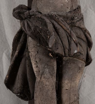 Zdjęcie nr 4: Pełnoplastyczna, ścięta w partii korpusu i bioder, polichromowana figura Chrystusa na prostym krzyżu, przybita trzema gwoździami i dodatkowym drewnianym kołkiem w partii bioder. Sylwetka zmarłego Chrystusa smukła, wychudła z wyraźnie zaznaczoną muskulaturą i układem kostnym klatki piersiowej. Ramiona uniesione wysoko tworzą łuk, nogi są lekko ugięte w kolanach, głowa opada na prawe ramię. Twarz pociągła, oczy zamknięte, nos niewielki, usta lekko otwarte. Na prawe ramię spływa pukiel długich włosów, broda krótka. Perizonium krótkie,  spięte na prawym boku.  Figura zmarłego Chrystusa pokryta polichromią imitującą naturalną karnację, widoczne są ślady męki. Perizonium ciemnobrązowe, włosy i zarost czarne.
