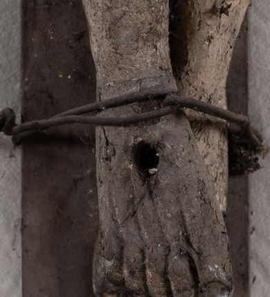 Zdjęcie nr 5: Pełnoplastyczna, ścięta w partii korpusu i bioder, polichromowana figura Chrystusa na prostym krzyżu, przybita trzema gwoździami i dodatkowym drewnianym kołkiem w partii bioder. Sylwetka zmarłego Chrystusa smukła, wychudła z wyraźnie zaznaczoną muskulaturą i układem kostnym klatki piersiowej. Ramiona uniesione wysoko tworzą łuk, nogi są lekko ugięte w kolanach, głowa opada na prawe ramię. Twarz pociągła, oczy zamknięte, nos niewielki, usta lekko otwarte. Na prawe ramię spływa pukiel długich włosów, broda krótka. Perizonium krótkie,  spięte na prawym boku.  Figura zmarłego Chrystusa pokryta polichromią imitującą naturalną karnację, widoczne są ślady męki. Perizonium ciemnobrązowe, włosy i zarost czarne.