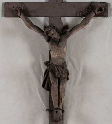 Zdjęcie nr 1: Pełnoplastyczna, ścięta w partii korpusu i bioder, polichromowana figura Chrystusa na prostym krzyżu, przybita trzema gwoździami i dodatkowym drewnianym kołkiem w partii bioder. Sylwetka zmarłego Chrystusa smukła, wychudła z wyraźnie zaznaczoną muskulaturą i układem kostnym klatki piersiowej. Ramiona uniesione wysoko tworzą łuk, nogi są lekko ugięte w kolanach, głowa opada na prawe ramię. Twarz pociągła, oczy zamknięte, nos niewielki, usta lekko otwarte. Na prawe ramię spływa pukiel długich włosów, broda krótka. Perizonium krótkie,  spięte na prawym boku.  Figura zmarłego Chrystusa pokryta polichromią imitującą naturalną karnację, widoczne są ślady męki. Perizonium ciemnobrązowe, włosy i zarost czarne.