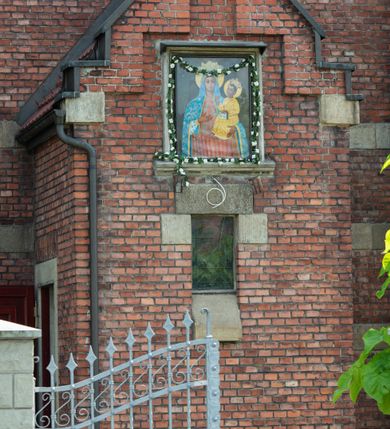 Zdjęcie nr 41: Kościół św. Jana Chrzciciela w Zembrzycach jest usytuowany na zachód od głównej drogi prowadzącej z Makowa Podhalańskiego do Wadowic i położony w centrum wsi, na placu otoczonym żeliwnym płotem na kamiennej podmurówce. Wejście na plac przykościelny prowadzi przez bramę od zachodu i wąską bramkę od północy. Kościół jest budowlą orientowaną, założoną na planie prostokąta, trójnawową, pseudohalową z prezbiterium zamkniętym trójbocznie, przy którym od północy znajduje się kaplica, a od południa piętrowa zakrystia z przedsionkiem i emporą otwartą na prezbiterium. Do nawy od strony północnej przylega wąska kruchta, nakryta dwuspadowym daszkiem. Od zachodu świątyni jest czworoboczna, masywna wieża, w górnej jednej trzeciej wysokości ośmioboczna, nakryta hełmem baniastym z latarnią. W fasadzie wysoka, półkolista wnęka z portalem i oknem termalnym. Przy wieży od północny składzik, a od południa kaplica. Ściany prezbiterium, nawy oraz elewacje aneksów w narożnikach artykułowane są szkarpami. Elewacje boczne zwieńczone ceglanym, zygzakowatym fryzem z krzyżykami. Szczyty na zakończeniach korpusu ozdobione kamiennymi szyszkami. W nawie okna trójdzielne z kamiennymi przezroczami, zamknięte łukami półkolistymi; w prezbiterium prostokątne zamknięte półkoliście. Świątynia nakryta jest dachem dwuspadowym. Na zakończeniu nawy znajduje się wieżyczka na sygnaturkę z baniastym hełmem. Wewnątrz nawy oddzielone są kolumnami z ośmiobocznymi głowicami, które wspierają sklepienia kolebkowe z lunetami. Empory i kaplice otwarte są arkadami półkolistymi. Prezbiterium podniesione jest o poziom dwóch stopni.
