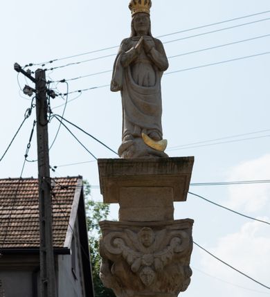 Zdjęcie nr 45: Kościół św. Jana Chrzciciela w Zembrzycach jest usytuowany na zachód od głównej drogi prowadzącej z Makowa Podhalańskiego do Wadowic i położony w centrum wsi, na placu otoczonym żeliwnym płotem na kamiennej podmurówce. Wejście na plac przykościelny prowadzi przez bramę od zachodu i wąską bramkę od północy. Kościół jest budowlą orientowaną, założoną na planie prostokąta, trójnawową, pseudohalową z prezbiterium zamkniętym trójbocznie, przy którym od północy znajduje się kaplica, a od południa piętrowa zakrystia z przedsionkiem i emporą otwartą na prezbiterium. Do nawy od strony północnej przylega wąska kruchta, nakryta dwuspadowym daszkiem. Od zachodu świątyni jest czworoboczna, masywna wieża, w górnej jednej trzeciej wysokości ośmioboczna, nakryta hełmem baniastym z latarnią. W fasadzie wysoka, półkolista wnęka z portalem i oknem termalnym. Przy wieży od północny składzik, a od południa kaplica. Ściany prezbiterium, nawy oraz elewacje aneksów w narożnikach artykułowane są szkarpami. Elewacje boczne zwieńczone ceglanym, zygzakowatym fryzem z krzyżykami. Szczyty na zakończeniach korpusu ozdobione kamiennymi szyszkami. W nawie okna trójdzielne z kamiennymi przezroczami, zamknięte łukami półkolistymi; w prezbiterium prostokątne zamknięte półkoliście. Świątynia nakryta jest dachem dwuspadowym. Na zakończeniu nawy znajduje się wieżyczka na sygnaturkę z baniastym hełmem. Wewnątrz nawy oddzielone są kolumnami z ośmiobocznymi głowicami, które wspierają sklepienia kolebkowe z lunetami. Empory i kaplice otwarte są arkadami półkolistymi. Prezbiterium podniesione jest o poziom dwóch stopni.
