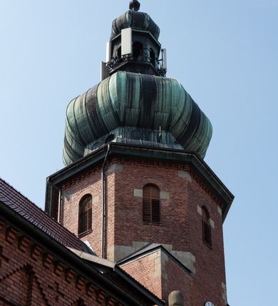 Zdjęcie nr 20: Kościół św. Jana Chrzciciela w Zembrzycach jest usytuowany na zachód od głównej drogi prowadzącej z Makowa Podhalańskiego do Wadowic i położony w centrum wsi, na placu otoczonym żeliwnym płotem na kamiennej podmurówce. Wejście na plac przykościelny prowadzi przez bramę od zachodu i wąską bramkę od północy. Kościół jest budowlą orientowaną, założoną na planie prostokąta, trójnawową, pseudohalową z prezbiterium zamkniętym trójbocznie, przy którym od północy znajduje się kaplica, a od południa piętrowa zakrystia z przedsionkiem i emporą otwartą na prezbiterium. Do nawy od strony północnej przylega wąska kruchta, nakryta dwuspadowym daszkiem. Od zachodu świątyni jest czworoboczna, masywna wieża, w górnej jednej trzeciej wysokości ośmioboczna, nakryta hełmem baniastym z latarnią. W fasadzie wysoka, półkolista wnęka z portalem i oknem termalnym. Przy wieży od północny składzik, a od południa kaplica. Ściany prezbiterium, nawy oraz elewacje aneksów w narożnikach artykułowane są szkarpami. Elewacje boczne zwieńczone ceglanym, zygzakowatym fryzem z krzyżykami. Szczyty na zakończeniach korpusu ozdobione kamiennymi szyszkami. W nawie okna trójdzielne z kamiennymi przezroczami, zamknięte łukami półkolistymi; w prezbiterium prostokątne zamknięte półkoliście. Świątynia nakryta jest dachem dwuspadowym. Na zakończeniu nawy znajduje się wieżyczka na sygnaturkę z baniastym hełmem. Wewnątrz nawy oddzielone są kolumnami z ośmiobocznymi głowicami, które wspierają sklepienia kolebkowe z lunetami. Empory i kaplice otwarte są arkadami półkolistymi. Prezbiterium podniesione jest o poziom dwóch stopni.
