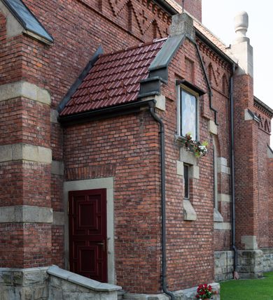 Zdjęcie nr 23: Kościół św. Jana Chrzciciela w Zembrzycach jest usytuowany na zachód od głównej drogi prowadzącej z Makowa Podhalańskiego do Wadowic i położony w centrum wsi, na placu otoczonym żeliwnym płotem na kamiennej podmurówce. Wejście na plac przykościelny prowadzi przez bramę od zachodu i wąską bramkę od północy. Kościół jest budowlą orientowaną, założoną na planie prostokąta, trójnawową, pseudohalową z prezbiterium zamkniętym trójbocznie, przy którym od północy znajduje się kaplica, a od południa piętrowa zakrystia z przedsionkiem i emporą otwartą na prezbiterium. Do nawy od strony północnej przylega wąska kruchta, nakryta dwuspadowym daszkiem. Od zachodu świątyni jest czworoboczna, masywna wieża, w górnej jednej trzeciej wysokości ośmioboczna, nakryta hełmem baniastym z latarnią. W fasadzie wysoka, półkolista wnęka z portalem i oknem termalnym. Przy wieży od północny składzik, a od południa kaplica. Ściany prezbiterium, nawy oraz elewacje aneksów w narożnikach artykułowane są szkarpami. Elewacje boczne zwieńczone ceglanym, zygzakowatym fryzem z krzyżykami. Szczyty na zakończeniach korpusu ozdobione kamiennymi szyszkami. W nawie okna trójdzielne z kamiennymi przezroczami, zamknięte łukami półkolistymi; w prezbiterium prostokątne zamknięte półkoliście. Świątynia nakryta jest dachem dwuspadowym. Na zakończeniu nawy znajduje się wieżyczka na sygnaturkę z baniastym hełmem. Wewnątrz nawy oddzielone są kolumnami z ośmiobocznymi głowicami, które wspierają sklepienia kolebkowe z lunetami. Empory i kaplice otwarte są arkadami półkolistymi. Prezbiterium podniesione jest o poziom dwóch stopni.
