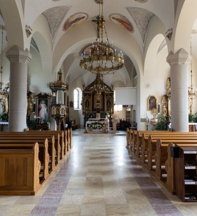 Zdjęcie nr 49: Kościół św. Jana Chrzciciela w Zembrzycach jest usytuowany na zachód od głównej drogi prowadzącej z Makowa Podhalańskiego do Wadowic i położony w centrum wsi, na placu otoczonym żeliwnym płotem na kamiennej podmurówce. Wejście na plac przykościelny prowadzi przez bramę od zachodu i wąską bramkę od północy. Kościół jest budowlą orientowaną, założoną na planie prostokąta, trójnawową, pseudohalową z prezbiterium zamkniętym trójbocznie, przy którym od północy znajduje się kaplica, a od południa piętrowa zakrystia z przedsionkiem i emporą otwartą na prezbiterium. Do nawy od strony północnej przylega wąska kruchta, nakryta dwuspadowym daszkiem. Od zachodu świątyni jest czworoboczna, masywna wieża, w górnej jednej trzeciej wysokości ośmioboczna, nakryta hełmem baniastym z latarnią. W fasadzie wysoka, półkolista wnęka z portalem i oknem termalnym. Przy wieży od północny składzik, a od południa kaplica. Ściany prezbiterium, nawy oraz elewacje aneksów w narożnikach artykułowane są szkarpami. Elewacje boczne zwieńczone ceglanym, zygzakowatym fryzem z krzyżykami. Szczyty na zakończeniach korpusu ozdobione kamiennymi szyszkami. W nawie okna trójdzielne z kamiennymi przezroczami, zamknięte łukami półkolistymi; w prezbiterium prostokątne zamknięte półkoliście. Świątynia nakryta jest dachem dwuspadowym. Na zakończeniu nawy znajduje się wieżyczka na sygnaturkę z baniastym hełmem. Wewnątrz nawy oddzielone są kolumnami z ośmiobocznymi głowicami, które wspierają sklepienia kolebkowe z lunetami. Empory i kaplice otwarte są arkadami półkolistymi. Prezbiterium podniesione jest o poziom dwóch stopni.
