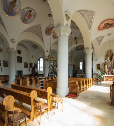 Zdjęcie nr 55: Kościół św. Jana Chrzciciela w Zembrzycach jest usytuowany na zachód od głównej drogi prowadzącej z Makowa Podhalańskiego do Wadowic i położony w centrum wsi, na placu otoczonym żeliwnym płotem na kamiennej podmurówce. Wejście na plac przykościelny prowadzi przez bramę od zachodu i wąską bramkę od północy. Kościół jest budowlą orientowaną, założoną na planie prostokąta, trójnawową, pseudohalową z prezbiterium zamkniętym trójbocznie, przy którym od północy znajduje się kaplica, a od południa piętrowa zakrystia z przedsionkiem i emporą otwartą na prezbiterium. Do nawy od strony północnej przylega wąska kruchta, nakryta dwuspadowym daszkiem. Od zachodu świątyni jest czworoboczna, masywna wieża, w górnej jednej trzeciej wysokości ośmioboczna, nakryta hełmem baniastym z latarnią. W fasadzie wysoka, półkolista wnęka z portalem i oknem termalnym. Przy wieży od północny składzik, a od południa kaplica. Ściany prezbiterium, nawy oraz elewacje aneksów w narożnikach artykułowane są szkarpami. Elewacje boczne zwieńczone ceglanym, zygzakowatym fryzem z krzyżykami. Szczyty na zakończeniach korpusu ozdobione kamiennymi szyszkami. W nawie okna trójdzielne z kamiennymi przezroczami, zamknięte łukami półkolistymi; w prezbiterium prostokątne zamknięte półkoliście. Świątynia nakryta jest dachem dwuspadowym. Na zakończeniu nawy znajduje się wieżyczka na sygnaturkę z baniastym hełmem. Wewnątrz nawy oddzielone są kolumnami z ośmiobocznymi głowicami, które wspierają sklepienia kolebkowe z lunetami. Empory i kaplice otwarte są arkadami półkolistymi. Prezbiterium podniesione jest o poziom dwóch stopni.
