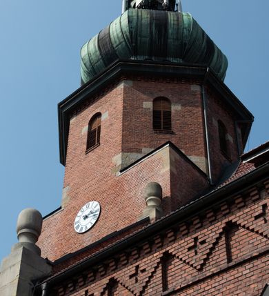 Zdjęcie nr 13: Kościół św. Jana Chrzciciela w Zembrzycach jest usytuowany na zachód od głównej drogi prowadzącej z Makowa Podhalańskiego do Wadowic i położony w centrum wsi, na placu otoczonym żeliwnym płotem na kamiennej podmurówce. Wejście na plac przykościelny prowadzi przez bramę od zachodu i wąską bramkę od północy. Kościół jest budowlą orientowaną, założoną na planie prostokąta, trójnawową, pseudohalową z prezbiterium zamkniętym trójbocznie, przy którym od północy znajduje się kaplica, a od południa piętrowa zakrystia z przedsionkiem i emporą otwartą na prezbiterium. Do nawy od strony północnej przylega wąska kruchta, nakryta dwuspadowym daszkiem. Od zachodu świątyni jest czworoboczna, masywna wieża, w górnej jednej trzeciej wysokości ośmioboczna, nakryta hełmem baniastym z latarnią. W fasadzie wysoka, półkolista wnęka z portalem i oknem termalnym. Przy wieży od północny składzik, a od południa kaplica. Ściany prezbiterium, nawy oraz elewacje aneksów w narożnikach artykułowane są szkarpami. Elewacje boczne zwieńczone ceglanym, zygzakowatym fryzem z krzyżykami. Szczyty na zakończeniach korpusu ozdobione kamiennymi szyszkami. W nawie okna trójdzielne z kamiennymi przezroczami, zamknięte łukami półkolistymi; w prezbiterium prostokątne zamknięte półkoliście. Świątynia nakryta jest dachem dwuspadowym. Na zakończeniu nawy znajduje się wieżyczka na sygnaturkę z baniastym hełmem. Wewnątrz nawy oddzielone są kolumnami z ośmiobocznymi głowicami, które wspierają sklepienia kolebkowe z lunetami. Empory i kaplice otwarte są arkadami półkolistymi. Prezbiterium podniesione jest o poziom dwóch stopni.
