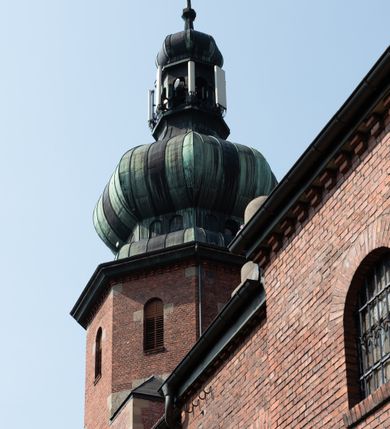 Zdjęcie nr 21: Kościół św. Jana Chrzciciela w Zembrzycach jest usytuowany na zachód od głównej drogi prowadzącej z Makowa Podhalańskiego do Wadowic i położony w centrum wsi, na placu otoczonym żeliwnym płotem na kamiennej podmurówce. Wejście na plac przykościelny prowadzi przez bramę od zachodu i wąską bramkę od północy. Kościół jest budowlą orientowaną, założoną na planie prostokąta, trójnawową, pseudohalową z prezbiterium zamkniętym trójbocznie, przy którym od północy znajduje się kaplica, a od południa piętrowa zakrystia z przedsionkiem i emporą otwartą na prezbiterium. Do nawy od strony północnej przylega wąska kruchta, nakryta dwuspadowym daszkiem. Od zachodu świątyni jest czworoboczna, masywna wieża, w górnej jednej trzeciej wysokości ośmioboczna, nakryta hełmem baniastym z latarnią. W fasadzie wysoka, półkolista wnęka z portalem i oknem termalnym. Przy wieży od północny składzik, a od południa kaplica. Ściany prezbiterium, nawy oraz elewacje aneksów w narożnikach artykułowane są szkarpami. Elewacje boczne zwieńczone ceglanym, zygzakowatym fryzem z krzyżykami. Szczyty na zakończeniach korpusu ozdobione kamiennymi szyszkami. W nawie okna trójdzielne z kamiennymi przezroczami, zamknięte łukami półkolistymi; w prezbiterium prostokątne zamknięte półkoliście. Świątynia nakryta jest dachem dwuspadowym. Na zakończeniu nawy znajduje się wieżyczka na sygnaturkę z baniastym hełmem. Wewnątrz nawy oddzielone są kolumnami z ośmiobocznymi głowicami, które wspierają sklepienia kolebkowe z lunetami. Empory i kaplice otwarte są arkadami półkolistymi. Prezbiterium podniesione jest o poziom dwóch stopni.
