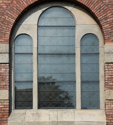 Zdjęcie nr 38: Kościół św. Jana Chrzciciela w Zembrzycach jest usytuowany na zachód od głównej drogi prowadzącej z Makowa Podhalańskiego do Wadowic i położony w centrum wsi, na placu otoczonym żeliwnym płotem na kamiennej podmurówce. Wejście na plac przykościelny prowadzi przez bramę od zachodu i wąską bramkę od północy. Kościół jest budowlą orientowaną, założoną na planie prostokąta, trójnawową, pseudohalową z prezbiterium zamkniętym trójbocznie, przy którym od północy znajduje się kaplica, a od południa piętrowa zakrystia z przedsionkiem i emporą otwartą na prezbiterium. Do nawy od strony północnej przylega wąska kruchta, nakryta dwuspadowym daszkiem. Od zachodu świątyni jest czworoboczna, masywna wieża, w górnej jednej trzeciej wysokości ośmioboczna, nakryta hełmem baniastym z latarnią. W fasadzie wysoka, półkolista wnęka z portalem i oknem termalnym. Przy wieży od północny składzik, a od południa kaplica. Ściany prezbiterium, nawy oraz elewacje aneksów w narożnikach artykułowane są szkarpami. Elewacje boczne zwieńczone ceglanym, zygzakowatym fryzem z krzyżykami. Szczyty na zakończeniach korpusu ozdobione kamiennymi szyszkami. W nawie okna trójdzielne z kamiennymi przezroczami, zamknięte łukami półkolistymi; w prezbiterium prostokątne zamknięte półkoliście. Świątynia nakryta jest dachem dwuspadowym. Na zakończeniu nawy znajduje się wieżyczka na sygnaturkę z baniastym hełmem. Wewnątrz nawy oddzielone są kolumnami z ośmiobocznymi głowicami, które wspierają sklepienia kolebkowe z lunetami. Empory i kaplice otwarte są arkadami półkolistymi. Prezbiterium podniesione jest o poziom dwóch stopni.
