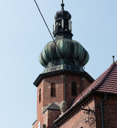 Zdjęcie nr 22: Kościół św. Jana Chrzciciela w Zembrzycach jest usytuowany na zachód od głównej drogi prowadzącej z Makowa Podhalańskiego do Wadowic i położony w centrum wsi, na placu otoczonym żeliwnym płotem na kamiennej podmurówce. Wejście na plac przykościelny prowadzi przez bramę od zachodu i wąską bramkę od północy. Kościół jest budowlą orientowaną, założoną na planie prostokąta, trójnawową, pseudohalową z prezbiterium zamkniętym trójbocznie, przy którym od północy znajduje się kaplica, a od południa piętrowa zakrystia z przedsionkiem i emporą otwartą na prezbiterium. Do nawy od strony północnej przylega wąska kruchta, nakryta dwuspadowym daszkiem. Od zachodu świątyni jest czworoboczna, masywna wieża, w górnej jednej trzeciej wysokości ośmioboczna, nakryta hełmem baniastym z latarnią. W fasadzie wysoka, półkolista wnęka z portalem i oknem termalnym. Przy wieży od północny składzik, a od południa kaplica. Ściany prezbiterium, nawy oraz elewacje aneksów w narożnikach artykułowane są szkarpami. Elewacje boczne zwieńczone ceglanym, zygzakowatym fryzem z krzyżykami. Szczyty na zakończeniach korpusu ozdobione kamiennymi szyszkami. W nawie okna trójdzielne z kamiennymi przezroczami, zamknięte łukami półkolistymi; w prezbiterium prostokątne zamknięte półkoliście. Świątynia nakryta jest dachem dwuspadowym. Na zakończeniu nawy znajduje się wieżyczka na sygnaturkę z baniastym hełmem. Wewnątrz nawy oddzielone są kolumnami z ośmiobocznymi głowicami, które wspierają sklepienia kolebkowe z lunetami. Empory i kaplice otwarte są arkadami półkolistymi. Prezbiterium podniesione jest o poziom dwóch stopni.
