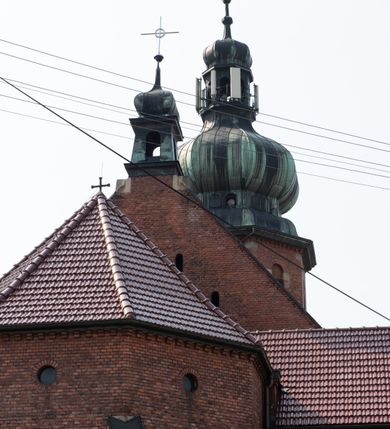 Zdjęcie nr 36: Kościół św. Jana Chrzciciela w Zembrzycach jest usytuowany na zachód od głównej drogi prowadzącej z Makowa Podhalańskiego do Wadowic i położony w centrum wsi, na placu otoczonym żeliwnym płotem na kamiennej podmurówce. Wejście na plac przykościelny prowadzi przez bramę od zachodu i wąską bramkę od północy. Kościół jest budowlą orientowaną, założoną na planie prostokąta, trójnawową, pseudohalową z prezbiterium zamkniętym trójbocznie, przy którym od północy znajduje się kaplica, a od południa piętrowa zakrystia z przedsionkiem i emporą otwartą na prezbiterium. Do nawy od strony północnej przylega wąska kruchta, nakryta dwuspadowym daszkiem. Od zachodu świątyni jest czworoboczna, masywna wieża, w górnej jednej trzeciej wysokości ośmioboczna, nakryta hełmem baniastym z latarnią. W fasadzie wysoka, półkolista wnęka z portalem i oknem termalnym. Przy wieży od północny składzik, a od południa kaplica. Ściany prezbiterium, nawy oraz elewacje aneksów w narożnikach artykułowane są szkarpami. Elewacje boczne zwieńczone ceglanym, zygzakowatym fryzem z krzyżykami. Szczyty na zakończeniach korpusu ozdobione kamiennymi szyszkami. W nawie okna trójdzielne z kamiennymi przezroczami, zamknięte łukami półkolistymi; w prezbiterium prostokątne zamknięte półkoliście. Świątynia nakryta jest dachem dwuspadowym. Na zakończeniu nawy znajduje się wieżyczka na sygnaturkę z baniastym hełmem. Wewnątrz nawy oddzielone są kolumnami z ośmiobocznymi głowicami, które wspierają sklepienia kolebkowe z lunetami. Empory i kaplice otwarte są arkadami półkolistymi. Prezbiterium podniesione jest o poziom dwóch stopni.
