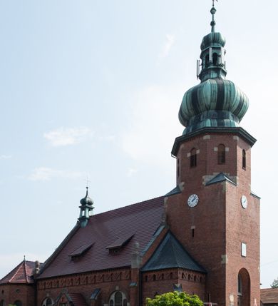 Zdjęcie nr 4: Kościół św. Jana Chrzciciela w Zembrzycach jest usytuowany na zachód od głównej drogi prowadzącej z Makowa Podhalańskiego do Wadowic i położony w centrum wsi, na placu otoczonym żeliwnym płotem na kamiennej podmurówce. Wejście na plac przykościelny prowadzi przez bramę od zachodu i wąską bramkę od północy. Kościół jest budowlą orientowaną, założoną na planie prostokąta, trójnawową, pseudohalową z prezbiterium zamkniętym trójbocznie, przy którym od północy znajduje się kaplica, a od południa piętrowa zakrystia z przedsionkiem i emporą otwartą na prezbiterium. Do nawy od strony północnej przylega wąska kruchta, nakryta dwuspadowym daszkiem. Od zachodu świątyni jest czworoboczna, masywna wieża, w górnej jednej trzeciej wysokości ośmioboczna, nakryta hełmem baniastym z latarnią. W fasadzie wysoka, półkolista wnęka z portalem i oknem termalnym. Przy wieży od północny składzik, a od południa kaplica. Ściany prezbiterium, nawy oraz elewacje aneksów w narożnikach artykułowane są szkarpami. Elewacje boczne zwieńczone ceglanym, zygzakowatym fryzem z krzyżykami. Szczyty na zakończeniach korpusu ozdobione kamiennymi szyszkami. W nawie okna trójdzielne z kamiennymi przezroczami, zamknięte łukami półkolistymi; w prezbiterium prostokątne zamknięte półkoliście. Świątynia nakryta jest dachem dwuspadowym. Na zakończeniu nawy znajduje się wieżyczka na sygnaturkę z baniastym hełmem. Wewnątrz nawy oddzielone są kolumnami z ośmiobocznymi głowicami, które wspierają sklepienia kolebkowe z lunetami. Empory i kaplice otwarte są arkadami półkolistymi. Prezbiterium podniesione jest o poziom dwóch stopni.
