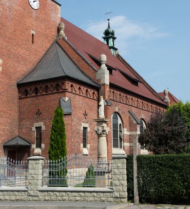 Zdjęcie nr 43: Kościół św. Jana Chrzciciela w Zembrzycach jest usytuowany na zachód od głównej drogi prowadzącej z Makowa Podhalańskiego do Wadowic i położony w centrum wsi, na placu otoczonym żeliwnym płotem na kamiennej podmurówce. Wejście na plac przykościelny prowadzi przez bramę od zachodu i wąską bramkę od północy. Kościół jest budowlą orientowaną, założoną na planie prostokąta, trójnawową, pseudohalową z prezbiterium zamkniętym trójbocznie, przy którym od północy znajduje się kaplica, a od południa piętrowa zakrystia z przedsionkiem i emporą otwartą na prezbiterium. Do nawy od strony północnej przylega wąska kruchta, nakryta dwuspadowym daszkiem. Od zachodu świątyni jest czworoboczna, masywna wieża, w górnej jednej trzeciej wysokości ośmioboczna, nakryta hełmem baniastym z latarnią. W fasadzie wysoka, półkolista wnęka z portalem i oknem termalnym. Przy wieży od północny składzik, a od południa kaplica. Ściany prezbiterium, nawy oraz elewacje aneksów w narożnikach artykułowane są szkarpami. Elewacje boczne zwieńczone ceglanym, zygzakowatym fryzem z krzyżykami. Szczyty na zakończeniach korpusu ozdobione kamiennymi szyszkami. W nawie okna trójdzielne z kamiennymi przezroczami, zamknięte łukami półkolistymi; w prezbiterium prostokątne zamknięte półkoliście. Świątynia nakryta jest dachem dwuspadowym. Na zakończeniu nawy znajduje się wieżyczka na sygnaturkę z baniastym hełmem. Wewnątrz nawy oddzielone są kolumnami z ośmiobocznymi głowicami, które wspierają sklepienia kolebkowe z lunetami. Empory i kaplice otwarte są arkadami półkolistymi. Prezbiterium podniesione jest o poziom dwóch stopni.
