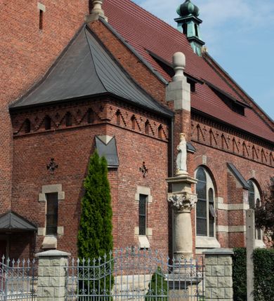 Zdjęcie nr 44: Kościół św. Jana Chrzciciela w Zembrzycach jest usytuowany na zachód od głównej drogi prowadzącej z Makowa Podhalańskiego do Wadowic i położony w centrum wsi, na placu otoczonym żeliwnym płotem na kamiennej podmurówce. Wejście na plac przykościelny prowadzi przez bramę od zachodu i wąską bramkę od północy. Kościół jest budowlą orientowaną, założoną na planie prostokąta, trójnawową, pseudohalową z prezbiterium zamkniętym trójbocznie, przy którym od północy znajduje się kaplica, a od południa piętrowa zakrystia z przedsionkiem i emporą otwartą na prezbiterium. Do nawy od strony północnej przylega wąska kruchta, nakryta dwuspadowym daszkiem. Od zachodu świątyni jest czworoboczna, masywna wieża, w górnej jednej trzeciej wysokości ośmioboczna, nakryta hełmem baniastym z latarnią. W fasadzie wysoka, półkolista wnęka z portalem i oknem termalnym. Przy wieży od północny składzik, a od południa kaplica. Ściany prezbiterium, nawy oraz elewacje aneksów w narożnikach artykułowane są szkarpami. Elewacje boczne zwieńczone ceglanym, zygzakowatym fryzem z krzyżykami. Szczyty na zakończeniach korpusu ozdobione kamiennymi szyszkami. W nawie okna trójdzielne z kamiennymi przezroczami, zamknięte łukami półkolistymi; w prezbiterium prostokątne zamknięte półkoliście. Świątynia nakryta jest dachem dwuspadowym. Na zakończeniu nawy znajduje się wieżyczka na sygnaturkę z baniastym hełmem. Wewnątrz nawy oddzielone są kolumnami z ośmiobocznymi głowicami, które wspierają sklepienia kolebkowe z lunetami. Empory i kaplice otwarte są arkadami półkolistymi. Prezbiterium podniesione jest o poziom dwóch stopni.
