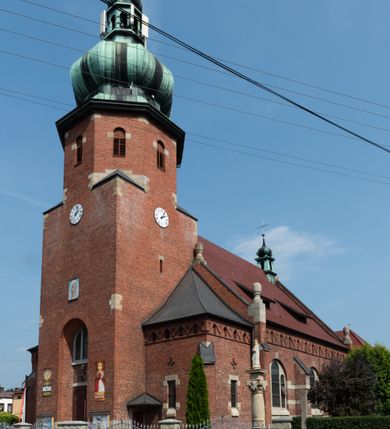 Zdjęcie nr 6: Kościół św. Jana Chrzciciela w Zembrzycach jest usytuowany na zachód od głównej drogi prowadzącej z Makowa Podhalańskiego do Wadowic i położony w centrum wsi, na placu otoczonym żeliwnym płotem na kamiennej podmurówce. Wejście na plac przykościelny prowadzi przez bramę od zachodu i wąską bramkę od północy. Kościół jest budowlą orientowaną, założoną na planie prostokąta, trójnawową, pseudohalową z prezbiterium zamkniętym trójbocznie, przy którym od północy znajduje się kaplica, a od południa piętrowa zakrystia z przedsionkiem i emporą otwartą na prezbiterium. Do nawy od strony północnej przylega wąska kruchta, nakryta dwuspadowym daszkiem. Od zachodu świątyni jest czworoboczna, masywna wieża, w górnej jednej trzeciej wysokości ośmioboczna, nakryta hełmem baniastym z latarnią. W fasadzie wysoka, półkolista wnęka z portalem i oknem termalnym. Przy wieży od północny składzik, a od południa kaplica. Ściany prezbiterium, nawy oraz elewacje aneksów w narożnikach artykułowane są szkarpami. Elewacje boczne zwieńczone ceglanym, zygzakowatym fryzem z krzyżykami. Szczyty na zakończeniach korpusu ozdobione kamiennymi szyszkami. W nawie okna trójdzielne z kamiennymi przezroczami, zamknięte łukami półkolistymi; w prezbiterium prostokątne zamknięte półkoliście. Świątynia nakryta jest dachem dwuspadowym. Na zakończeniu nawy znajduje się wieżyczka na sygnaturkę z baniastym hełmem. Wewnątrz nawy oddzielone są kolumnami z ośmiobocznymi głowicami, które wspierają sklepienia kolebkowe z lunetami. Empory i kaplice otwarte są arkadami półkolistymi. Prezbiterium podniesione jest o poziom dwóch stopni.
