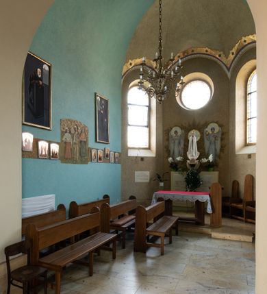 Zdjęcie nr 58: Kościół św. Jana Chrzciciela w Zembrzycach jest usytuowany na zachód od głównej drogi prowadzącej z Makowa Podhalańskiego do Wadowic i położony w centrum wsi, na placu otoczonym żeliwnym płotem na kamiennej podmurówce. Wejście na plac przykościelny prowadzi przez bramę od zachodu i wąską bramkę od północy. Kościół jest budowlą orientowaną, założoną na planie prostokąta, trójnawową, pseudohalową z prezbiterium zamkniętym trójbocznie, przy którym od północy znajduje się kaplica, a od południa piętrowa zakrystia z przedsionkiem i emporą otwartą na prezbiterium. Do nawy od strony północnej przylega wąska kruchta, nakryta dwuspadowym daszkiem. Od zachodu świątyni jest czworoboczna, masywna wieża, w górnej jednej trzeciej wysokości ośmioboczna, nakryta hełmem baniastym z latarnią. W fasadzie wysoka, półkolista wnęka z portalem i oknem termalnym. Przy wieży od północny składzik, a od południa kaplica. Ściany prezbiterium, nawy oraz elewacje aneksów w narożnikach artykułowane są szkarpami. Elewacje boczne zwieńczone ceglanym, zygzakowatym fryzem z krzyżykami. Szczyty na zakończeniach korpusu ozdobione kamiennymi szyszkami. W nawie okna trójdzielne z kamiennymi przezroczami, zamknięte łukami półkolistymi; w prezbiterium prostokątne zamknięte półkoliście. Świątynia nakryta jest dachem dwuspadowym. Na zakończeniu nawy znajduje się wieżyczka na sygnaturkę z baniastym hełmem. Wewnątrz nawy oddzielone są kolumnami z ośmiobocznymi głowicami, które wspierają sklepienia kolebkowe z lunetami. Empory i kaplice otwarte są arkadami półkolistymi. Prezbiterium podniesione jest o poziom dwóch stopni.
