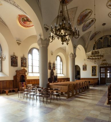 Zdjęcie nr 61: Kościół św. Jana Chrzciciela w Zembrzycach jest usytuowany na zachód od głównej drogi prowadzącej z Makowa Podhalańskiego do Wadowic i położony w centrum wsi, na placu otoczonym żeliwnym płotem na kamiennej podmurówce. Wejście na plac przykościelny prowadzi przez bramę od zachodu i wąską bramkę od północy. Kościół jest budowlą orientowaną, założoną na planie prostokąta, trójnawową, pseudohalową z prezbiterium zamkniętym trójbocznie, przy którym od północy znajduje się kaplica, a od południa piętrowa zakrystia z przedsionkiem i emporą otwartą na prezbiterium. Do nawy od strony północnej przylega wąska kruchta, nakryta dwuspadowym daszkiem. Od zachodu świątyni jest czworoboczna, masywna wieża, w górnej jednej trzeciej wysokości ośmioboczna, nakryta hełmem baniastym z latarnią. W fasadzie wysoka, półkolista wnęka z portalem i oknem termalnym. Przy wieży od północny składzik, a od południa kaplica. Ściany prezbiterium, nawy oraz elewacje aneksów w narożnikach artykułowane są szkarpami. Elewacje boczne zwieńczone ceglanym, zygzakowatym fryzem z krzyżykami. Szczyty na zakończeniach korpusu ozdobione kamiennymi szyszkami. W nawie okna trójdzielne z kamiennymi przezroczami, zamknięte łukami półkolistymi; w prezbiterium prostokątne zamknięte półkoliście. Świątynia nakryta jest dachem dwuspadowym. Na zakończeniu nawy znajduje się wieżyczka na sygnaturkę z baniastym hełmem. Wewnątrz nawy oddzielone są kolumnami z ośmiobocznymi głowicami, które wspierają sklepienia kolebkowe z lunetami. Empory i kaplice otwarte są arkadami półkolistymi. Prezbiterium podniesione jest o poziom dwóch stopni.
