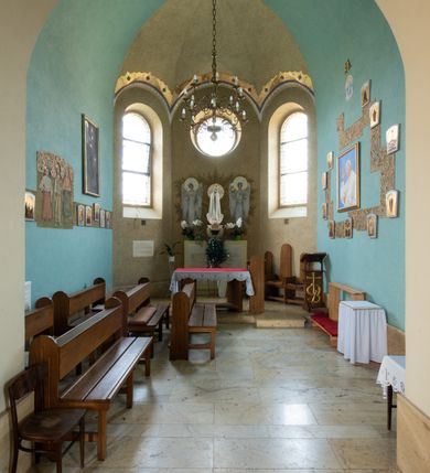 Zdjęcie nr 59: Kościół św. Jana Chrzciciela w Zembrzycach jest usytuowany na zachód od głównej drogi prowadzącej z Makowa Podhalańskiego do Wadowic i położony w centrum wsi, na placu otoczonym żeliwnym płotem na kamiennej podmurówce. Wejście na plac przykościelny prowadzi przez bramę od zachodu i wąską bramkę od północy. Kościół jest budowlą orientowaną, założoną na planie prostokąta, trójnawową, pseudohalową z prezbiterium zamkniętym trójbocznie, przy którym od północy znajduje się kaplica, a od południa piętrowa zakrystia z przedsionkiem i emporą otwartą na prezbiterium. Do nawy od strony północnej przylega wąska kruchta, nakryta dwuspadowym daszkiem. Od zachodu świątyni jest czworoboczna, masywna wieża, w górnej jednej trzeciej wysokości ośmioboczna, nakryta hełmem baniastym z latarnią. W fasadzie wysoka, półkolista wnęka z portalem i oknem termalnym. Przy wieży od północny składzik, a od południa kaplica. Ściany prezbiterium, nawy oraz elewacje aneksów w narożnikach artykułowane są szkarpami. Elewacje boczne zwieńczone ceglanym, zygzakowatym fryzem z krzyżykami. Szczyty na zakończeniach korpusu ozdobione kamiennymi szyszkami. W nawie okna trójdzielne z kamiennymi przezroczami, zamknięte łukami półkolistymi; w prezbiterium prostokątne zamknięte półkoliście. Świątynia nakryta jest dachem dwuspadowym. Na zakończeniu nawy znajduje się wieżyczka na sygnaturkę z baniastym hełmem. Wewnątrz nawy oddzielone są kolumnami z ośmiobocznymi głowicami, które wspierają sklepienia kolebkowe z lunetami. Empory i kaplice otwarte są arkadami półkolistymi. Prezbiterium podniesione jest o poziom dwóch stopni.
