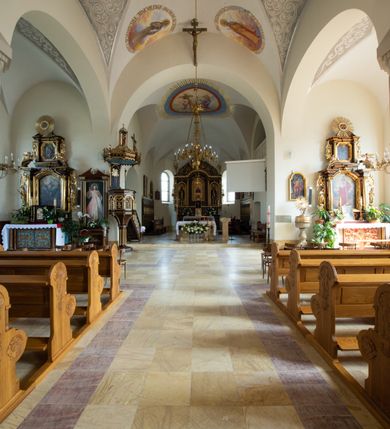 Zdjęcie nr 66: Kościół św. Jana Chrzciciela w Zembrzycach jest usytuowany na zachód od głównej drogi prowadzącej z Makowa Podhalańskiego do Wadowic i położony w centrum wsi, na placu otoczonym żeliwnym płotem na kamiennej podmurówce. Wejście na plac przykościelny prowadzi przez bramę od zachodu i wąską bramkę od północy. Kościół jest budowlą orientowaną, założoną na planie prostokąta, trójnawową, pseudohalową z prezbiterium zamkniętym trójbocznie, przy którym od północy znajduje się kaplica, a od południa piętrowa zakrystia z przedsionkiem i emporą otwartą na prezbiterium. Do nawy od strony północnej przylega wąska kruchta, nakryta dwuspadowym daszkiem. Od zachodu świątyni jest czworoboczna, masywna wieża, w górnej jednej trzeciej wysokości ośmioboczna, nakryta hełmem baniastym z latarnią. W fasadzie wysoka, półkolista wnęka z portalem i oknem termalnym. Przy wieży od północny składzik, a od południa kaplica. Ściany prezbiterium, nawy oraz elewacje aneksów w narożnikach artykułowane są szkarpami. Elewacje boczne zwieńczone ceglanym, zygzakowatym fryzem z krzyżykami. Szczyty na zakończeniach korpusu ozdobione kamiennymi szyszkami. W nawie okna trójdzielne z kamiennymi przezroczami, zamknięte łukami półkolistymi; w prezbiterium prostokątne zamknięte półkoliście. Świątynia nakryta jest dachem dwuspadowym. Na zakończeniu nawy znajduje się wieżyczka na sygnaturkę z baniastym hełmem. Wewnątrz nawy oddzielone są kolumnami z ośmiobocznymi głowicami, które wspierają sklepienia kolebkowe z lunetami. Empory i kaplice otwarte są arkadami półkolistymi. Prezbiterium podniesione jest o poziom dwóch stopni.
