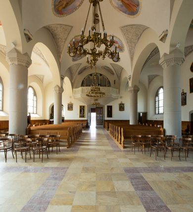 Zdjęcie nr 64: Kościół św. Jana Chrzciciela w Zembrzycach jest usytuowany na zachód od głównej drogi prowadzącej z Makowa Podhalańskiego do Wadowic i położony w centrum wsi, na placu otoczonym żeliwnym płotem na kamiennej podmurówce. Wejście na plac przykościelny prowadzi przez bramę od zachodu i wąską bramkę od północy. Kościół jest budowlą orientowaną, założoną na planie prostokąta, trójnawową, pseudohalową z prezbiterium zamkniętym trójbocznie, przy którym od północy znajduje się kaplica, a od południa piętrowa zakrystia z przedsionkiem i emporą otwartą na prezbiterium. Do nawy od strony północnej przylega wąska kruchta, nakryta dwuspadowym daszkiem. Od zachodu świątyni jest czworoboczna, masywna wieża, w górnej jednej trzeciej wysokości ośmioboczna, nakryta hełmem baniastym z latarnią. W fasadzie wysoka, półkolista wnęka z portalem i oknem termalnym. Przy wieży od północny składzik, a od południa kaplica. Ściany prezbiterium, nawy oraz elewacje aneksów w narożnikach artykułowane są szkarpami. Elewacje boczne zwieńczone ceglanym, zygzakowatym fryzem z krzyżykami. Szczyty na zakończeniach korpusu ozdobione kamiennymi szyszkami. W nawie okna trójdzielne z kamiennymi przezroczami, zamknięte łukami półkolistymi; w prezbiterium prostokątne zamknięte półkoliście. Świątynia nakryta jest dachem dwuspadowym. Na zakończeniu nawy znajduje się wieżyczka na sygnaturkę z baniastym hełmem. Wewnątrz nawy oddzielone są kolumnami z ośmiobocznymi głowicami, które wspierają sklepienia kolebkowe z lunetami. Empory i kaplice otwarte są arkadami półkolistymi. Prezbiterium podniesione jest o poziom dwóch stopni.
