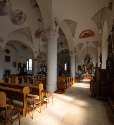 Zdjęcie nr 70: Kościół św. Jana Chrzciciela w Zembrzycach jest usytuowany na zachód od głównej drogi prowadzącej z Makowa Podhalańskiego do Wadowic i położony w centrum wsi, na placu otoczonym żeliwnym płotem na kamiennej podmurówce. Wejście na plac przykościelny prowadzi przez bramę od zachodu i wąską bramkę od północy. Kościół jest budowlą orientowaną, założoną na planie prostokąta, trójnawową, pseudohalową z prezbiterium zamkniętym trójbocznie, przy którym od północy znajduje się kaplica, a od południa piętrowa zakrystia z przedsionkiem i emporą otwartą na prezbiterium. Do nawy od strony północnej przylega wąska kruchta, nakryta dwuspadowym daszkiem. Od zachodu świątyni jest czworoboczna, masywna wieża, w górnej jednej trzeciej wysokości ośmioboczna, nakryta hełmem baniastym z latarnią. W fasadzie wysoka, półkolista wnęka z portalem i oknem termalnym. Przy wieży od północny składzik, a od południa kaplica. Ściany prezbiterium, nawy oraz elewacje aneksów w narożnikach artykułowane są szkarpami. Elewacje boczne zwieńczone ceglanym, zygzakowatym fryzem z krzyżykami. Szczyty na zakończeniach korpusu ozdobione kamiennymi szyszkami. W nawie okna trójdzielne z kamiennymi przezroczami, zamknięte łukami półkolistymi; w prezbiterium prostokątne zamknięte półkoliście. Świątynia nakryta jest dachem dwuspadowym. Na zakończeniu nawy znajduje się wieżyczka na sygnaturkę z baniastym hełmem. Wewnątrz nawy oddzielone są kolumnami z ośmiobocznymi głowicami, które wspierają sklepienia kolebkowe z lunetami. Empory i kaplice otwarte są arkadami półkolistymi. Prezbiterium podniesione jest o poziom dwóch stopni.
