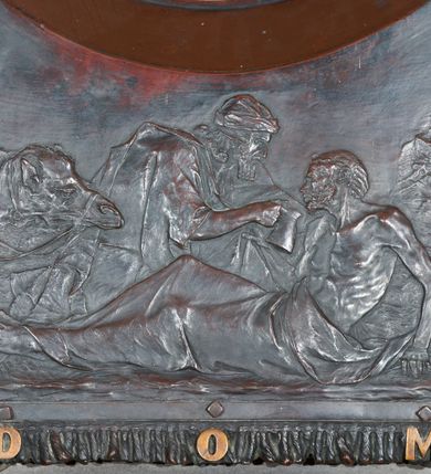 Zdjęcie nr 5: Epitafium w kształcie stojącego prostokąta, dwustopniowe, oddzielone wąskim gzymsem, zamknięte łukiem półkolistym, na którego zakończeniach dwie puste tarcze herbowe. W dolnej części epitafium płycina w kształcie leżącego prostokąta o fantazyjnym wykroju, w narożach ujęta dwiema czołgankami, z inskrypcją w polu: „LUDWIK BEŁTOWSKI / UR[ODZONY] 1819 WE LWOWIE ZASŁ[UŻONY] OBYW[ATEL] DŁUG[O]L[ETNI] RADNY MIASTA / NOWEGO TARGU MISTRZ ART[YSTA] BUD[OWLI] MECH[ANICZNYCH] PRZEM[YSŁOWYCH] PRZEWODN[ICZĄCY] / POW[IATOWEGO] STOW[ARZYSZENIA] RĘKODZ[IĘLNIKÓW] PRZEM[YSŁOWYCH] SĄDU POLUB[OWNEGO] INICIAT[OR] CZYNN[Y] ORĘD[OWNIK] / POWIĘKSZ[ANIA] MAJ[ĄTKU] DOBROBYTU GMINY UPIĘKSZ[ANIA] MIASTA OFIARN[Y] / PATRIOT[A] MĄŻ RZADK[ICH] CNÓT SERC[A] WIELK[IEGO] CHAR[AKTERU] ZM[ARŁ] 13. STYCZ[NIA] 1902 / PROSI O WESTCHNIENIE DO BOGA AMEN”. W prawym dolnym rogu epitafium sygnatura „Juliusz B[ełtowski] 1904.” Powyżej kwadratowy odlew z przedstawieniem Miłosiernego Samarytanina, flankowany dwiema popiersiami: rzeźbą Matki Boskiej z Dzieciątkiem po prawej i św. Józefa Robotnika po lewej. W dolnej części odlewu litery „D[EO] O[PTIMO] M[AXIMO]”. Na odlewie ukazany leżący na ziemi mężczyzna o wychudzonej posturze, któremu Samarytanin podaje kubek z wodą do picia. Po lewej stronie obrazu głowa wielbłąda. Matka Boska zwrócona trzy czwarte w lewo, z głową pochyloną w dół, przytulająca do piersi śpiące Dzieciątko. W dłoniach trzyma księgę. Twarz o wyraźnych rysach z długim nosem i zaciśniętymi ustami. Ubrana jest w suknię z długimi rękawami i płaszcz założony na głowę. Święty Józef zwrócony jest delikatnie w prawo z głową skierowaną w lewo. Ma krótkie i bujne włosy, wzrok skierowany w prawo oraz zaciśnięte usta. Ubrany jest w strój robotnika – koszulę z podwiniętymi do łokci rękawami. W dłoniach trzyma strug i piłę do drewna. W górnej części epitafium znajduje się okrągłe popiersie Ludwika Bełtowskiego w szerokiej okrągłej ramie. Zmarły ukazany z prawego profilu o podłużnej twarzy ze spiczastą brodą i wąsami, długim nosem i zmarszczonym czołem. Włosy krótkie. Ubrany jest w koszulę i marynarkę. Po lewej stronie popiersia sygnatura „B[ełtowski] [1]902”.


