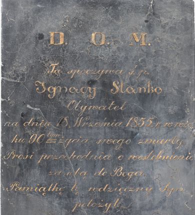 Zdjęcie nr 1: Epitafium w kształcie stojącego prostokąta. W polu kuta, złocona inskrypcja „D(EO) O(PTIMO) M(AXIMO) / Tu spoczywa ś(więtej) p(amięci) / Ignacy Stanko / Obywatel / na dniu 18. Września 1855. r(oku) w wie/ku 90 tym życia swego zmarły. / Prosi przechodnia o westchnienie / za sobą do Boga. / Pamiątkę tę wdzięczny Syn / położył. / A(leksander) S(tanko)”.
