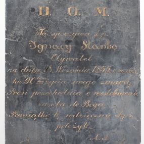 Zdjęcie nr 1: Epitafium w kształcie stojącego prostokąta. W polu kuta, złocona inskrypcja „D(EO) O(PTIMO) M(AXIMO) / Tu spoczywa ś(więtej) p(amięci) / Ignacy Stanko / Obywatel / na dniu 18. Września 1855. r(oku) w wie/ku 90 tym życia swego zmarły. / Prosi przechodnia o westchnienie / za sobą do Boga. / Pamiątkę tę wdzięczny Syn / położył. / A(leksander) S(tanko)”.