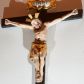 Zdjęcie nr 1: Krucyfiks z rzeźbą Chrystusa w typie Cristo morte. Rzeźba pełna; głowa przechylona na prawe ramię; nogi delikatnie ugięte w kolanach, stopy przebite jednym gwoździem w układzie prawa na lewą. Twarz pociągła, o wyraźnych rysach, okolona jasnobrązową brodą. Na głowie Chrystus ma nimb krzyżowy złożony z trzech wiązek promieni. Sylwetka wychudzona, ciało z silnie zaznaczonymi żebrami klatki piersiowej i mostkiem. Perizonium przewiązane na prawym boku. Nad głową Zbawiciela znajduje się owalny kartusz z napisem „INRI” w polu. Polichromia naturalistyczna w odsłoniętych partiach ciała z zaznaczonymi śladami męki, perizonium złocone, kartusz złocony i srebrzony. Krzyż prosty, drewniany, malowany na czarno.