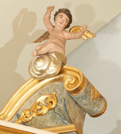 Zdjęcie nr 13: Nastawa ołtarzowa architektoniczna, jednoosiowa z bramkami, jednokondygnacyjna ze zwieńczeniem; na podwójnym cokole, zryzalitowanym w narożach. Ołtarz murowany, prostopadłościenny, w drewnianej obudowie; mensa drewniana. Antepedium proste, w formie leżącego prostokąta, obwiedzione profilowaną, złoconą ramą, w polu marmoryzowane. Tabernakulum w formie prostopadłościennej skrzynki o ściętych narożach z przodu, obite fakturowaną blachą zdobioną literami alfa i omega; w trójosiowej, drewnianej obudowie. Nad tabernakulum tron wystawienia w formie obrotowej niszy, z jednej strony zakończonej u góry wieńcem utworzonym z kwiatów i muszli, ujętej ramą utworzoną z wieńca laurowego, z glorią promienistą w polu i medalionem z napisem: „ŚWIĘTY, ŚWIETY, ŚWIĘTY”. Z drugiej strony przypominającą kaplicę kopułową z niszą z krucyfiksem, ujętą przez pilastry zdobione kampanulami; kopuła z płaskorzeźbionym przedstawieniem krzewu winnego grona i pęków zbóż. Osie boczne w formie aediculi flankowanych przez parę kolumienek, ustawionych na cokołach, dźwigających belkowanie. W prawej osi ustawiona niewielka figurka Matki Boskiej z Dzieciątkiem. Struktura ujęta uszami utworzonymi z liści akantu. 

Retabulum flankowane parą zdwojonych półfilarów, dźwigających pełne belkowanie z silnie wysuniętym gzymsem, nad polem głównym wyłamujące się w formę łuku odcinkowego oraz przerwany wolutowy przyczółek. Na osi podpór ustawione są pod kątem imposty, podtrzymywane przez płaskie muszle. W polu głównym kondygnacji obraz z przedstawieniem św. Katarzyny Aleksandryjskiej w prostokątnej, profilowanej ramie zamknięty łukiem półkolistym nadwieszonym, flankowany parą pilastrów o kapitelach kompozytowych i skręconych oraz spłaszczonych trzonach. Obraz ten stanowi zasuwę dla grupy Ukrzyżowania. Na kolejnych zasuwach obrazy: Najświętszego Serca Pana Jezusa w widzeniu św. Małgorzaty Marii Alacoque oraz papieża Jana Pawła II.
Cokoły dekorowane są płycinami z liśćmi akantu. Kondygnacja ujęta jest uszami utworzonymi z liści akantu i stylizowanej muszli. Trzony filarów zdobione są stylizowanymi kampanulami, a fryz dekorowany płycinami utworzonymi z liści akantu. Nad polem głównym zawieszone są cztery uskrzydlone główki anielskie pośród obłoków.

Zwieńczenie w formie stojącego prostokąta, ujęte parą lizen, zamknięte gzymsem i szczytem z krzyżem. W polu obraz w formie owalu z przedstawieniem św. Jakuba z Matką Boską z Pilar. Pole zwieńczenia ujęte jest spływami utworzonymi z liści akantu, wstęgi i rozetek kwiatowych; lizeny dekorowane kampanulami; w narożach pola dekoracja roślinna. Szczyt utworzony z krzyża ujętego spływami wolutowymi o wstędze przechodzącej w akant z dwiema rozetami kwiatowymi. Na przerwanym przyczółku siedzi para aniołków. Po bokach ołtarza bramki ujęte parami pilastrów na cokołach, podtrzymującymi belkowanie oraz przerwany przyczółek z cokołem pośrodku z figurami aniołów. Drzwi bramek w formie stojącego prostokąta zamkniętego łukiem półkolistym z płyciną zamkniętą łukiem półkolistym nadwieszonym w polu.
Struktura marmoryzowana w kolorze niebieskim, filary bladoróżowym; profile i ornamentyka złocone i srebrzone.

