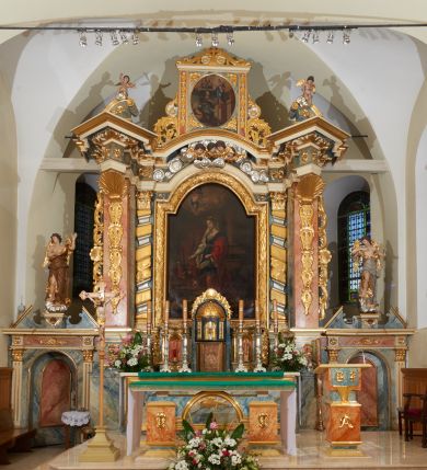 Zdjęcie nr 1: Nastawa ołtarzowa architektoniczna, jednoosiowa z bramkami, jednokondygnacyjna ze zwieńczeniem; na podwójnym cokole, zryzalitowanym w narożach. Ołtarz murowany, prostopadłościenny, w drewnianej obudowie; mensa drewniana. Antepedium proste, w formie leżącego prostokąta, obwiedzione profilowaną, złoconą ramą, w polu marmoryzowane. Tabernakulum w formie prostopadłościennej skrzynki o ściętych narożach z przodu, obite fakturowaną blachą zdobioną literami alfa i omega; w trójosiowej, drewnianej obudowie. Nad tabernakulum tron wystawienia w formie obrotowej niszy, z jednej strony zakończonej u góry wieńcem utworzonym z kwiatów i muszli, ujętej ramą utworzoną z wieńca laurowego, z glorią promienistą w polu i medalionem z napisem: „ŚWIĘTY, ŚWIETY, ŚWIĘTY”. Z drugiej strony przypominającą kaplicę kopułową z niszą z krucyfiksem, ujętą przez pilastry zdobione kampanulami; kopuła z płaskorzeźbionym przedstawieniem krzewu winnego grona i pęków zbóż. Osie boczne w formie aediculi flankowanych przez parę kolumienek, ustawionych na cokołach, dźwigających belkowanie. W prawej osi ustawiona niewielka figurka Matki Boskiej z Dzieciątkiem. Struktura ujęta uszami utworzonymi z liści akantu. 

Retabulum flankowane parą zdwojonych półfilarów, dźwigających pełne belkowanie z silnie wysuniętym gzymsem, nad polem głównym wyłamujące się w formę łuku odcinkowego oraz przerwany wolutowy przyczółek. Na osi podpór ustawione są pod kątem imposty, podtrzymywane przez płaskie muszle. W polu głównym kondygnacji obraz z przedstawieniem św. Katarzyny Aleksandryjskiej w prostokątnej, profilowanej ramie zamknięty łukiem półkolistym nadwieszonym, flankowany parą pilastrów o kapitelach kompozytowych i skręconych oraz spłaszczonych trzonach. Obraz ten stanowi zasuwę dla grupy Ukrzyżowania. Na kolejnych zasuwach obrazy: Najświętszego Serca Pana Jezusa w widzeniu św. Małgorzaty Marii Alacoque oraz papieża Jana Pawła II.
Cokoły dekorowane są płycinami z liśćmi akantu. Kondygnacja ujęta jest uszami utworzonymi z liści akantu i stylizowanej muszli. Trzony filarów zdobione są stylizowanymi kampanulami, a fryz dekorowany płycinami utworzonymi z liści akantu. Nad polem głównym zawieszone są cztery uskrzydlone główki anielskie pośród obłoków.

Zwieńczenie w formie stojącego prostokąta, ujęte parą lizen, zamknięte gzymsem i szczytem z krzyżem. W polu obraz w formie owalu z przedstawieniem św. Jakuba z Matką Boską z Pilar. Pole zwieńczenia ujęte jest spływami utworzonymi z liści akantu, wstęgi i rozetek kwiatowych; lizeny dekorowane kampanulami; w narożach pola dekoracja roślinna. Szczyt utworzony z krzyża ujętego spływami wolutowymi o wstędze przechodzącej w akant z dwiema rozetami kwiatowymi. Na przerwanym przyczółku siedzi para aniołków. Po bokach ołtarza bramki ujęte parami pilastrów na cokołach, podtrzymującymi belkowanie oraz przerwany przyczółek z cokołem pośrodku z figurami aniołów. Drzwi bramek w formie stojącego prostokąta zamkniętego łukiem półkolistym z płyciną zamkniętą łukiem półkolistym nadwieszonym w polu.
Struktura marmoryzowana w kolorze niebieskim, filary bladoróżowym; profile i ornamentyka złocone i srebrzone.
