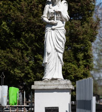 Zdjęcie nr 16: Kościół murowany z cegły, z użyciem zendrówki, na wysokim podmurowaniu z kamienia łupanego, jednonawowy, orientowany. 
Prezbiterium i nawa na planie prostokątów, nawa szersza i dłuższa od prezbiterium. Zakrystia na rzucie wydłużonego prostokąta przylega do wschodniej ściany prezbiterium, występując poza mury nawy. Prezbiterium od wschodu ujęte w narożach dwiema ukośnymi szkarpami, od południa jedną prostopadłą. Przy południowej ścianie nawy kruchta na planie kwadratu. Nawa w narożach ujęta szkarpami, od wschodu dwiema prostopadłymi, od zachodu ukośnymi. 
Prezbiterium dwuprzęsłowe, nakryte sklepieniem krzyżowo-żebrowym. Na zwornikach dwie tarcze z herbami Trzy Korony i Wieniawa. Zakrystia sklepiona kolebkowo. Nawa nakryta drewnianym stropem z kasetonami i rozetami. Kruchta sklepiona krzyżowo-żebrowo ze zwornikiem z tarczą z herbem Wieniawa. Otwór tęczowy w formie stojącego prostokąta zamkniętego łukiem ostrym. W zachodniej części nawy drewniany parapet chóru muzycznego wsparty na dwóch filarach. 
Fasada w jednej trzeciej wysokości odcięta kamiennym gzymsem kapnikowym, zakończona jodełkowym fryzem w partii muru, zwieńczona trójkątnym szczytem. Mur dekorowany zendrówką ułożoną „w zęby”, w partii szczytu w układzie rombowym. Na osi kamienny ostrołukowy portal o schodkowym nadprożu, dekorowanym krzyżującym się laskowaniem; węgary gładkie w jednej trzeciej wysokości przechodzące w piramidki i profilowanie powyżej. Nad portalem kamienna kwadratowa tablica, ujęta kamiennym obramieniem z tarczą z herbem Wieniawa. Ponad nią, na osi okulus w kamiennym obramieniu. 
Elewacje północna i południowa w części nawy w jednej trzeciej wysokości przedzielone kamiennym gzymsem kapnikowym, na zakończeniu ścian z gzymsem wieńczącym. Mur dekorowany zendrówką w układzie rombowym. Na elewacji południowej cztery okna w formie wydłużonego, stojącego prostokąta zamkniętego łukiem ostrym, w kamiennych obramieniach, podzielone laskowaniem. Południowa ściana prezbiterium zakończona gzymsem wieńczącym, w górnej części muru dekorowana zendrówką ułożoną „w zęby”. 
Szkarpy opinające nawę uskokowe, zwężające się ku górze, nakryte daszkami pulpitowymi. Szkarpy opinające prezbiterium nakryte daszkami pulpitowymi, podzielone gzymsami kapnikowymi. 
Kruchta od strony wschodniej i zachodniej podzielona kamiennym gzymsem kapnikowym, od południa zakończona gzymsem wieńczącym. Na ścianie południowej kruchty kamienny, ostrołukowy portal, o schodkowym nadprożu, dekorowanym krzyżującym się laskowaniem; węgary gładkie, w jednej trzeciej wysokości przechodzące w piramidki i profilowanie powyżej. Nad portalem kamienna tarcza z herbem Wieniawa. 
Elewacja wschodnia zwieńczona trójkątnym szczytem, w którego partii mur dekorowany jest zendrówką w układzie rombowym. Na osi okno w formie wydłużonego, stojącego prostokąta zamkniętego łukiem ostrym, w kamiennym obramieniu, zamurowane w trzech piątych wysokości, zakończone daszkiem pulpitowym. W dolnej części okna znajduje się ogrójec. 
Nawa i prezbiterium nakryte osobnymi blaszanymi dachami dwuspadowymi, kruchta i zakrystia pulpitowymi. Nad nawą blaszana wieżyczka na sygnaturkę z latarnią i hełmem baniastym.





