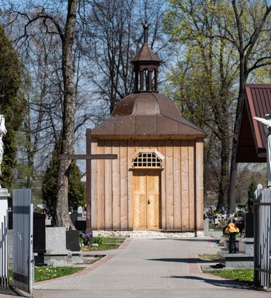 Zdjęcie nr 20: Kościół murowany z cegły, z użyciem zendrówki, na wysokim podmurowaniu z kamienia łupanego, jednonawowy, orientowany. 
Prezbiterium i nawa na planie prostokątów, nawa szersza i dłuższa od prezbiterium. Zakrystia na rzucie wydłużonego prostokąta przylega do wschodniej ściany prezbiterium, występując poza mury nawy. Prezbiterium od wschodu ujęte w narożach dwiema ukośnymi szkarpami, od południa jedną prostopadłą. Przy południowej ścianie nawy kruchta na planie kwadratu. Nawa w narożach ujęta szkarpami, od wschodu dwiema prostopadłymi, od zachodu ukośnymi. 
Prezbiterium dwuprzęsłowe, nakryte sklepieniem krzyżowo-żebrowym. Na zwornikach dwie tarcze z herbami Trzy Korony i Wieniawa. Zakrystia sklepiona kolebkowo. Nawa nakryta drewnianym stropem z kasetonami i rozetami. Kruchta sklepiona krzyżowo-żebrowo ze zwornikiem z tarczą z herbem Wieniawa. Otwór tęczowy w formie stojącego prostokąta zamkniętego łukiem ostrym. W zachodniej części nawy drewniany parapet chóru muzycznego wsparty na dwóch filarach. 
Fasada w jednej trzeciej wysokości odcięta kamiennym gzymsem kapnikowym, zakończona jodełkowym fryzem w partii muru, zwieńczona trójkątnym szczytem. Mur dekorowany zendrówką ułożoną „w zęby”, w partii szczytu w układzie rombowym. Na osi kamienny ostrołukowy portal o schodkowym nadprożu, dekorowanym krzyżującym się laskowaniem; węgary gładkie w jednej trzeciej wysokości przechodzące w piramidki i profilowanie powyżej. Nad portalem kamienna kwadratowa tablica, ujęta kamiennym obramieniem z tarczą z herbem Wieniawa. Ponad nią, na osi okulus w kamiennym obramieniu. 
Elewacje północna i południowa w części nawy w jednej trzeciej wysokości przedzielone kamiennym gzymsem kapnikowym, na zakończeniu ścian z gzymsem wieńczącym. Mur dekorowany zendrówką w układzie rombowym. Na elewacji południowej cztery okna w formie wydłużonego, stojącego prostokąta zamkniętego łukiem ostrym, w kamiennych obramieniach, podzielone laskowaniem. Południowa ściana prezbiterium zakończona gzymsem wieńczącym, w górnej części muru dekorowana zendrówką ułożoną „w zęby”. 
Szkarpy opinające nawę uskokowe, zwężające się ku górze, nakryte daszkami pulpitowymi. Szkarpy opinające prezbiterium nakryte daszkami pulpitowymi, podzielone gzymsami kapnikowymi. 
Kruchta od strony wschodniej i zachodniej podzielona kamiennym gzymsem kapnikowym, od południa zakończona gzymsem wieńczącym. Na ścianie południowej kruchty kamienny, ostrołukowy portal, o schodkowym nadprożu, dekorowanym krzyżującym się laskowaniem; węgary gładkie, w jednej trzeciej wysokości przechodzące w piramidki i profilowanie powyżej. Nad portalem kamienna tarcza z herbem Wieniawa. 
Elewacja wschodnia zwieńczona trójkątnym szczytem, w którego partii mur dekorowany jest zendrówką w układzie rombowym. Na osi okno w formie wydłużonego, stojącego prostokąta zamkniętego łukiem ostrym, w kamiennym obramieniu, zamurowane w trzech piątych wysokości, zakończone daszkiem pulpitowym. W dolnej części okna znajduje się ogrójec. 
Nawa i prezbiterium nakryte osobnymi blaszanymi dachami dwuspadowymi, kruchta i zakrystia pulpitowymi. Nad nawą blaszana wieżyczka na sygnaturkę z latarnią i hełmem baniastym.





