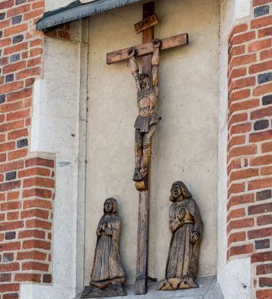 Zdjęcie nr 115: Kościół murowany z cegły, z użyciem zendrówki, na wysokim podmurowaniu z kamienia łupanego, jednonawowy, orientowany. 
Prezbiterium i nawa na planie prostokątów, nawa szersza i dłuższa od prezbiterium. Zakrystia na rzucie wydłużonego prostokąta przylega do wschodniej ściany prezbiterium, występując poza mury nawy. Prezbiterium od wschodu ujęte w narożach dwiema ukośnymi szkarpami, od południa jedną prostopadłą. Przy południowej ścianie nawy kruchta na planie kwadratu. Nawa w narożach ujęta szkarpami, od wschodu dwiema prostopadłymi, od zachodu ukośnymi. 
Prezbiterium dwuprzęsłowe, nakryte sklepieniem krzyżowo-żebrowym. Na zwornikach dwie tarcze z herbami Trzy Korony i Wieniawa. Zakrystia sklepiona kolebkowo. Nawa nakryta drewnianym stropem z kasetonami i rozetami. Kruchta sklepiona krzyżowo-żebrowo ze zwornikiem z tarczą z herbem Wieniawa. Otwór tęczowy w formie stojącego prostokąta zamkniętego łukiem ostrym. W zachodniej części nawy drewniany parapet chóru muzycznego wsparty na dwóch filarach. 
Fasada w jednej trzeciej wysokości odcięta kamiennym gzymsem kapnikowym, zakończona jodełkowym fryzem w partii muru, zwieńczona trójkątnym szczytem. Mur dekorowany zendrówką ułożoną „w zęby”, w partii szczytu w układzie rombowym. Na osi kamienny ostrołukowy portal o schodkowym nadprożu, dekorowanym krzyżującym się laskowaniem; węgary gładkie w jednej trzeciej wysokości przechodzące w piramidki i profilowanie powyżej. Nad portalem kamienna kwadratowa tablica, ujęta kamiennym obramieniem z tarczą z herbem Wieniawa. Ponad nią, na osi okulus w kamiennym obramieniu. 
Elewacje północna i południowa w części nawy w jednej trzeciej wysokości przedzielone kamiennym gzymsem kapnikowym, na zakończeniu ścian z gzymsem wieńczącym. Mur dekorowany zendrówką w układzie rombowym. Na elewacji południowej cztery okna w formie wydłużonego, stojącego prostokąta zamkniętego łukiem ostrym, w kamiennych obramieniach, podzielone laskowaniem. Południowa ściana prezbiterium zakończona gzymsem wieńczącym, w górnej części muru dekorowana zendrówką ułożoną „w zęby”. 
Szkarpy opinające nawę uskokowe, zwężające się ku górze, nakryte daszkami pulpitowymi. Szkarpy opinające prezbiterium nakryte daszkami pulpitowymi, podzielone gzymsami kapnikowymi. 
Kruchta od strony wschodniej i zachodniej podzielona kamiennym gzymsem kapnikowym, od południa zakończona gzymsem wieńczącym. Na ścianie południowej kruchty kamienny, ostrołukowy portal, o schodkowym nadprożu, dekorowanym krzyżującym się laskowaniem; węgary gładkie, w jednej trzeciej wysokości przechodzące w piramidki i profilowanie powyżej. Nad portalem kamienna tarcza z herbem Wieniawa. 
Elewacja wschodnia zwieńczona trójkątnym szczytem, w którego partii mur dekorowany jest zendrówką w układzie rombowym. Na osi okno w formie wydłużonego, stojącego prostokąta zamkniętego łukiem ostrym, w kamiennym obramieniu, zamurowane w trzech piątych wysokości, zakończone daszkiem pulpitowym. W dolnej części okna znajduje się ogrójec. 
Nawa i prezbiterium nakryte osobnymi blaszanymi dachami dwuspadowymi, kruchta i zakrystia pulpitowymi. Nad nawą blaszana wieżyczka na sygnaturkę z latarnią i hełmem baniastym.





