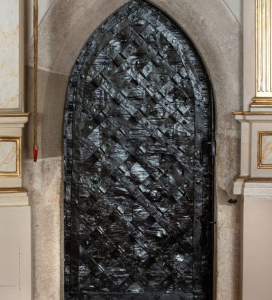 Zdjęcie nr 28: Kościół murowany z cegły, z użyciem zendrówki, na wysokim podmurowaniu z kamienia łupanego, jednonawowy, orientowany. 
Prezbiterium i nawa na planie prostokątów, nawa szersza i dłuższa od prezbiterium. Zakrystia na rzucie wydłużonego prostokąta przylega do wschodniej ściany prezbiterium, występując poza mury nawy. Prezbiterium od wschodu ujęte w narożach dwiema ukośnymi szkarpami, od południa jedną prostopadłą. Przy południowej ścianie nawy kruchta na planie kwadratu. Nawa w narożach ujęta szkarpami, od wschodu dwiema prostopadłymi, od zachodu ukośnymi. 
Prezbiterium dwuprzęsłowe, nakryte sklepieniem krzyżowo-żebrowym. Na zwornikach dwie tarcze z herbami Trzy Korony i Wieniawa. Zakrystia sklepiona kolebkowo. Nawa nakryta drewnianym stropem z kasetonami i rozetami. Kruchta sklepiona krzyżowo-żebrowo ze zwornikiem z tarczą z herbem Wieniawa. Otwór tęczowy w formie stojącego prostokąta zamkniętego łukiem ostrym. W zachodniej części nawy drewniany parapet chóru muzycznego wsparty na dwóch filarach. 
Fasada w jednej trzeciej wysokości odcięta kamiennym gzymsem kapnikowym, zakończona jodełkowym fryzem w partii muru, zwieńczona trójkątnym szczytem. Mur dekorowany zendrówką ułożoną „w zęby”, w partii szczytu w układzie rombowym. Na osi kamienny ostrołukowy portal o schodkowym nadprożu, dekorowanym krzyżującym się laskowaniem; węgary gładkie w jednej trzeciej wysokości przechodzące w piramidki i profilowanie powyżej. Nad portalem kamienna kwadratowa tablica, ujęta kamiennym obramieniem z tarczą z herbem Wieniawa. Ponad nią, na osi okulus w kamiennym obramieniu. 
Elewacje północna i południowa w części nawy w jednej trzeciej wysokości przedzielone kamiennym gzymsem kapnikowym, na zakończeniu ścian z gzymsem wieńczącym. Mur dekorowany zendrówką w układzie rombowym. Na elewacji południowej cztery okna w formie wydłużonego, stojącego prostokąta zamkniętego łukiem ostrym, w kamiennych obramieniach, podzielone laskowaniem. Południowa ściana prezbiterium zakończona gzymsem wieńczącym, w górnej części muru dekorowana zendrówką ułożoną „w zęby”. 
Szkarpy opinające nawę uskokowe, zwężające się ku górze, nakryte daszkami pulpitowymi. Szkarpy opinające prezbiterium nakryte daszkami pulpitowymi, podzielone gzymsami kapnikowymi. 
Kruchta od strony wschodniej i zachodniej podzielona kamiennym gzymsem kapnikowym, od południa zakończona gzymsem wieńczącym. Na ścianie południowej kruchty kamienny, ostrołukowy portal, o schodkowym nadprożu, dekorowanym krzyżującym się laskowaniem; węgary gładkie, w jednej trzeciej wysokości przechodzące w piramidki i profilowanie powyżej. Nad portalem kamienna tarcza z herbem Wieniawa. 
Elewacja wschodnia zwieńczona trójkątnym szczytem, w którego partii mur dekorowany jest zendrówką w układzie rombowym. Na osi okno w formie wydłużonego, stojącego prostokąta zamkniętego łukiem ostrym, w kamiennym obramieniu, zamurowane w trzech piątych wysokości, zakończone daszkiem pulpitowym. W dolnej części okna znajduje się ogrójec. 
Nawa i prezbiterium nakryte osobnymi blaszanymi dachami dwuspadowymi, kruchta i zakrystia pulpitowymi. Nad nawą blaszana wieżyczka na sygnaturkę z latarnią i hełmem baniastym.





