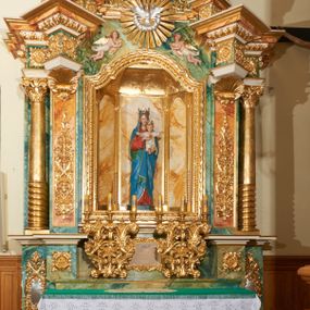 Zdjęcie nr 1: Ołtarz przyścienny, architektoniczny, jednoosiowy, jednokondygnacyjny ze zwieńczeniem. Mensa prostopadłościenna, w antepedium prostokątna płycina ujęta parą kolumienek wspartych na cokołach, ozdobiona aplikowanym krzyżem i dwiema ukośnie spiętymi gałązkami z liśćmi i kwiatami. Retabulum ustawione na wysokim, dwustrefowym cokole, zamkniętym wyłamanym i profilowanym gzymsem. Nastawa ołtarzowa ujęta parą filarów i kolumn ustawionych na tle pilastrów. Trzony kolumn do jednej trzeciej wysokości spiralnie skręcone, powyżej gładkie z grawerowaną wicią winorośli; trzony pilastrów wypełnione prostokątnymi płycinami ze stylizowaną wicią roślinną; kapitele podpór korynckie. Podpory wspierają wyłamane belkowanie, przerwane nad częścią środkową, zamknięte wydatnym, profilowanym gzymsem. W polu środkowym nastawy zamknięta trójbocznie wnęka ze zdwojoną ramą w kształcie stojącego prostokąta, zamkniętego łukiem wklęsło-wypukłym z uskokami z rzeźbą Matki Boskiej z Dzieciątkiem oraz obrazami „Św. Józef” oraz „Św. Agnieszka” na zasuwie. Na osi filarów, w partii belkowania ustawione są pod kątem imposty, podtrzymywane przez płaskie i stylizowane muszle; pośrodku gołębica Ducha Świętego na tle promienistej glorii, a poniżej dwie płaskorzeźbione figury aniołów.  Zwieńczenie w kształcie stojącego prostokąta, ujęte parą ukośnie dostawionych filarów, wspierających wyłamane belkowanie. W polu środkowym owalny obraz „Nauczanie Marii”. Na szczycie zwieńczenia figura św. Michała Archanioła. Dekoracja ornamentalna: przednie ścianki cokołów dekorowane rozetami, po bokach cokołów owalne kartusze ujęte stylizowanymi liśćmi akantu; fryz dekorowany rozetami kwiatowymi; po bokach zwieńczenia uszaki formowane z ażurowej wici roślinnej. Całość struktury ołtarza pokryta marmoryzacją zielono-niebieską; w dolnej części cokołu, w płycinach i w partiach belkowania w kolorze czerwono-pomarańczowym. Detale oraz profilowania pozłacane i posrebrzane. 
