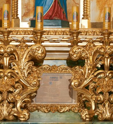 Zdjęcie nr 5: Ołtarz przyścienny, architektoniczny, jednoosiowy, jednokondygnacyjny ze zwieńczeniem. Mensa prostopadłościenna, w antepedium prostokątna płycina ujęta parą kolumienek wspartych na cokołach, ozdobiona aplikowanym krzyżem i dwiema ukośnie spiętymi gałązkami z liśćmi i kwiatami. Retabulum ustawione na wysokim, dwustrefowym cokole, zamkniętym wyłamanym i profilowanym gzymsem. Nastawa ołtarzowa ujęta parą filarów i kolumn ustawionych na tle pilastrów. Trzony kolumn do jednej trzeciej wysokości spiralnie skręcone, powyżej gładkie z grawerowaną wicią winorośli; trzony pilastrów wypełnione prostokątnymi płycinami ze stylizowaną wicią roślinną; kapitele podpór korynckie. Podpory wspierają wyłamane belkowanie, przerwane nad częścią środkową, zamknięte wydatnym, profilowanym gzymsem. W polu środkowym nastawy zamknięta trójbocznie wnęka ze zdwojoną ramą w kształcie stojącego prostokąta, zamkniętego łukiem wklęsło-wypukłym z uskokami z rzeźbą Matki Boskiej z Dzieciątkiem oraz obrazami „Św. Józef” oraz „Św. Agnieszka” na zasuwie. Na osi filarów, w partii belkowania ustawione są pod kątem imposty, podtrzymywane przez płaskie i stylizowane muszle; pośrodku gołębica Ducha Świętego na tle promienistej glorii, a poniżej dwie płaskorzeźbione figury aniołów.  Zwieńczenie w kształcie stojącego prostokąta, ujęte parą ukośnie dostawionych filarów, wspierających wyłamane belkowanie. W polu środkowym owalny obraz „Nauczanie Marii”. Na szczycie zwieńczenia figura św. Michała Archanioła. Dekoracja ornamentalna: przednie ścianki cokołów dekorowane rozetami, po bokach cokołów owalne kartusze ujęte stylizowanymi liśćmi akantu; fryz dekorowany rozetami kwiatowymi; po bokach zwieńczenia uszaki formowane z ażurowej wici roślinnej. Całość struktury ołtarza pokryta marmoryzacją zielono-niebieską; w dolnej części cokołu, w płycinach i w partiach belkowania w kolorze czerwono-pomarańczowym. Detale oraz profilowania pozłacane i posrebrzane. 
