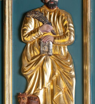 Zdjęcie nr 8: Ambona przyścienna, wisząca, z dostępem od zakrystii. Kosz na planie czterech boków z sześcioboku, na cokole w formie spłaszczonego wałka, z podwieszonym niewielkim cokolikiem zakończonym szyszką. Ścianki wydzielone pilastrami o kanelowanych trzonach, na cokołach, dźwigającymi parapet w formie gzymsu, wyłamany na ich osi. W polach ścianek płyciny o kształcie stojącego prostokąta z płaskorzeźbionymi przedstawieniami czterech ewangelistów. Zaplecek w formie wydłużonego, stojącego prostokąta, ujętego pilastrami o kanelowanych trzonach, zakończonych konsolami dekorowanymi liściem akantu, dźwigającymi imposty oraz przerwany, półokrągły przyczółek. W polu zaplecka drzwiczki do zakrystii, zdobione dwiema arkadami; ponad nimi płaskorzeźbione tablice praw. Baldachim na planie analogicznym względem kosza, w formie kopułki na wklęsłym, zwężającym się cokole dekorowanym płycinami, zakończonej latarnią z krzyżem na kuli. Brzeg w postaci gzymsu wyłamanego na osi podpór kosza, z siedzącymi nań puttami oraz z podwieszonym lambrekinem. Na podniebiu baldachimu rzeźbiona gołębica Ducha Świętego w glorii promienistej. 
Struktura polichromowana w kolorze szaro-niebieskim, profile i ornamentyka złocone.